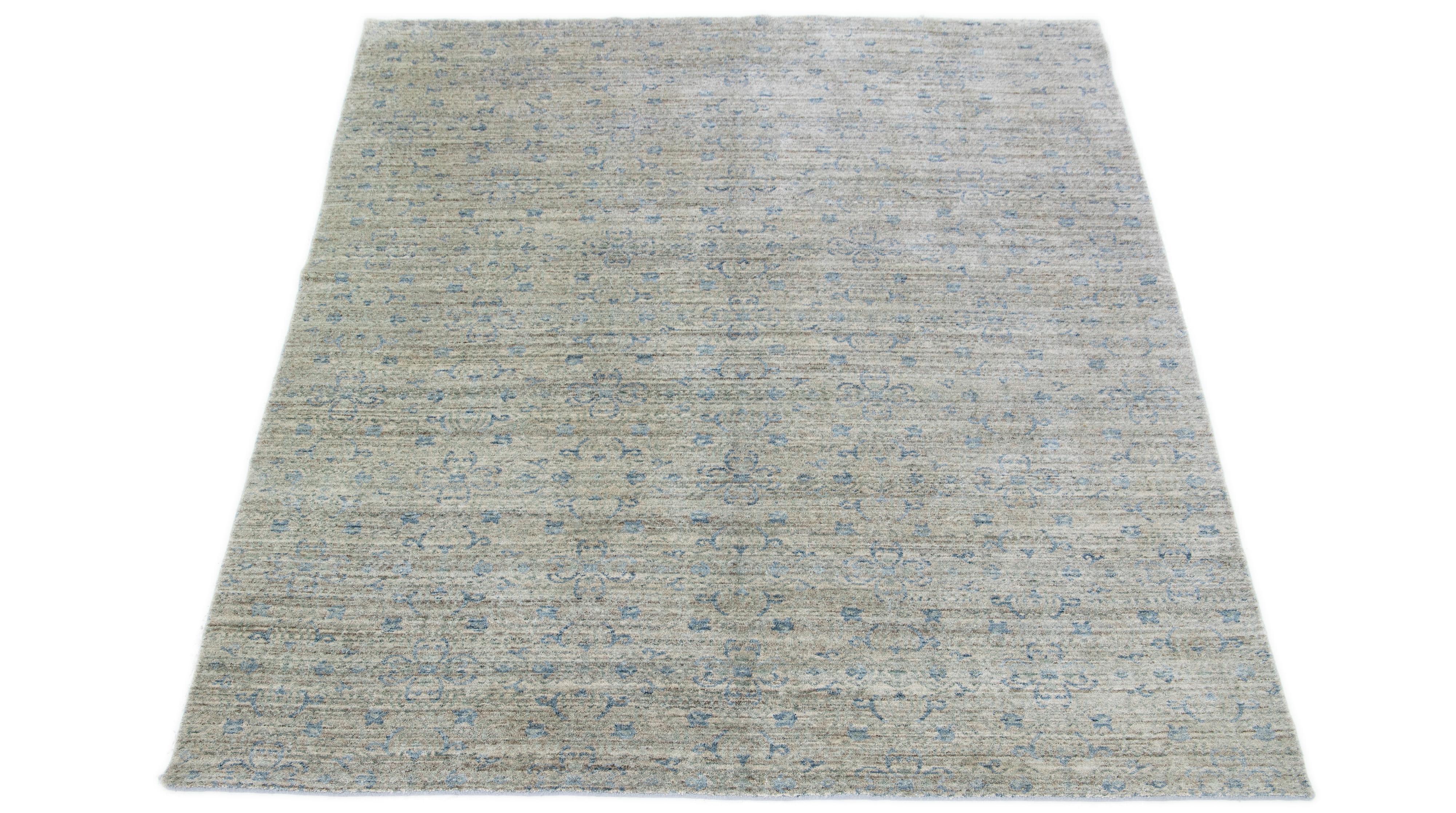 This elegant rug, made from wool and silk, displays an enthralling floral pattern in blue and light green hues, expertly embodied over a seductive light gray base tone.

This rug measures 7'11