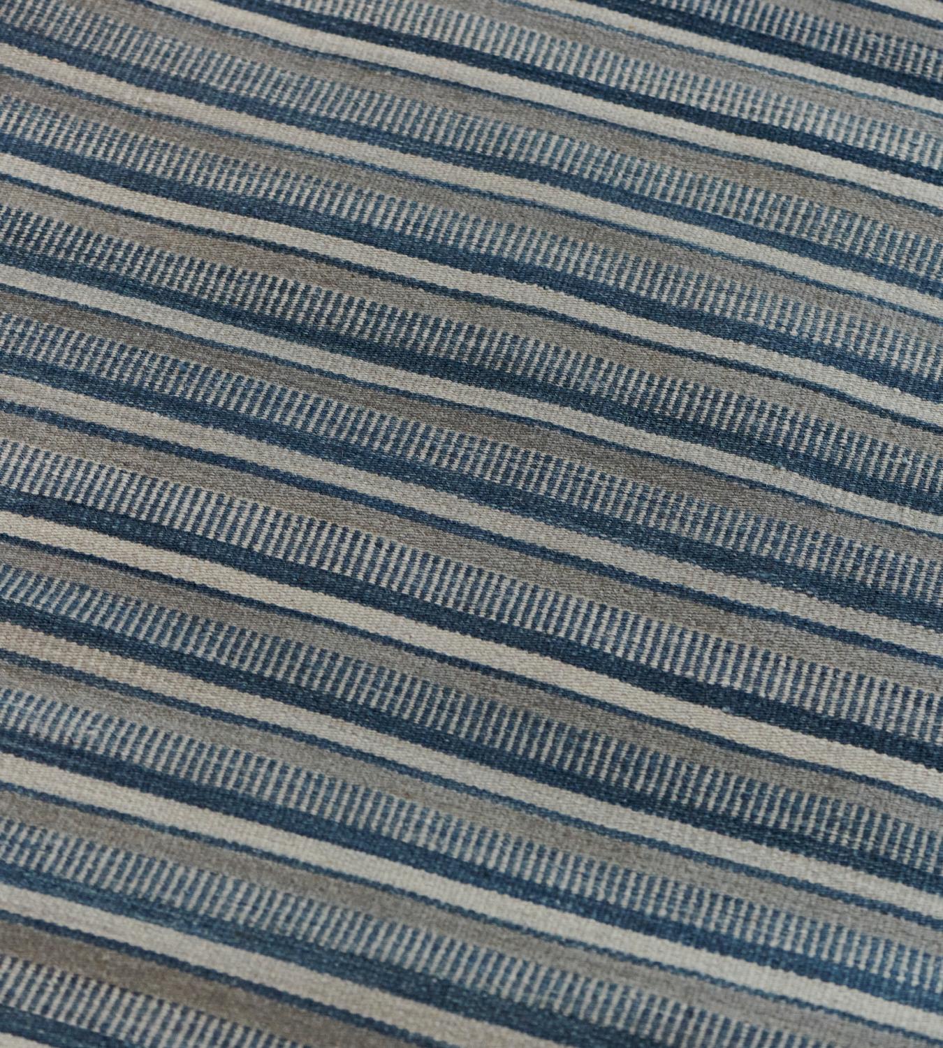 Part of the Mansour Modern collection, this flat-weave blue striped rug is handwoven by master weavers using the finest quality techniques and materials.