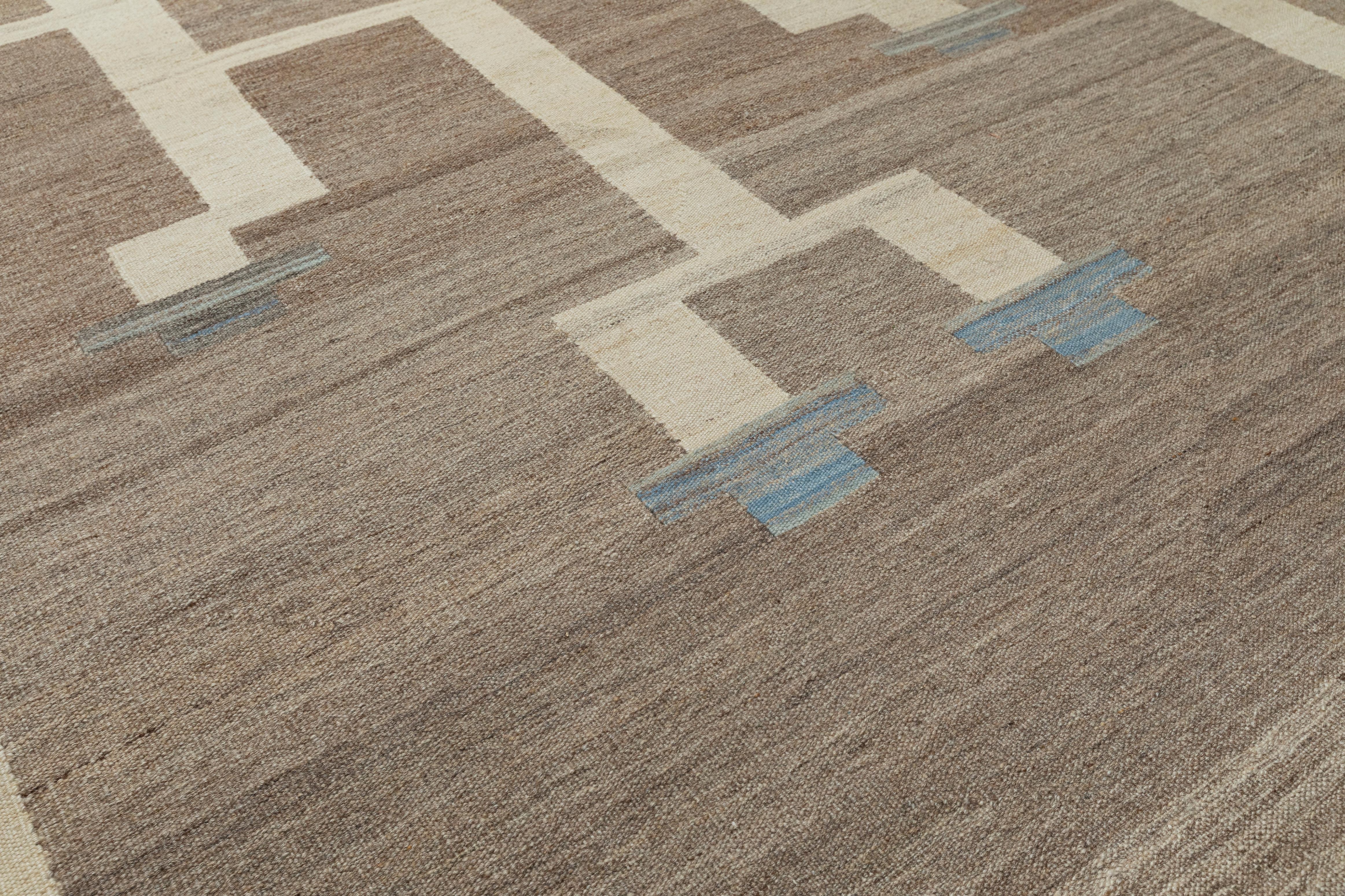 Questo tappeto moderno in lana a trama piatta intrecciata a mano dona al tuo spazio una raffinatezza senza sforzo. Realizzato con precisione da abili artigiani, questo pezzo contemporaneo presenta un motivo geometrico pulito a griglia nei toni caldi