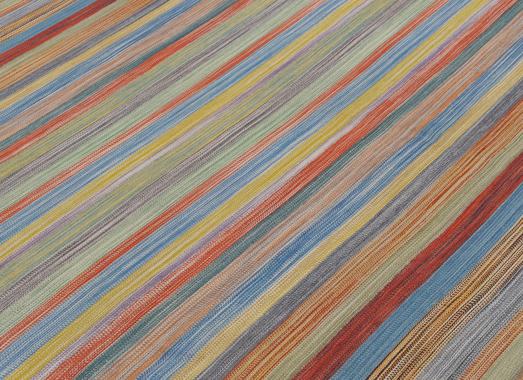 Dieser moderne, handgewebte Kelim aus dem Iran besteht zu 100 % aus natürlicher Wolle und wird von geschickten Kunsthandwerkern in altehrwürdigen persischen Webtechniken gefertigt. Das lebendige, mehrfarbige Streifenmuster bringt eine frische und