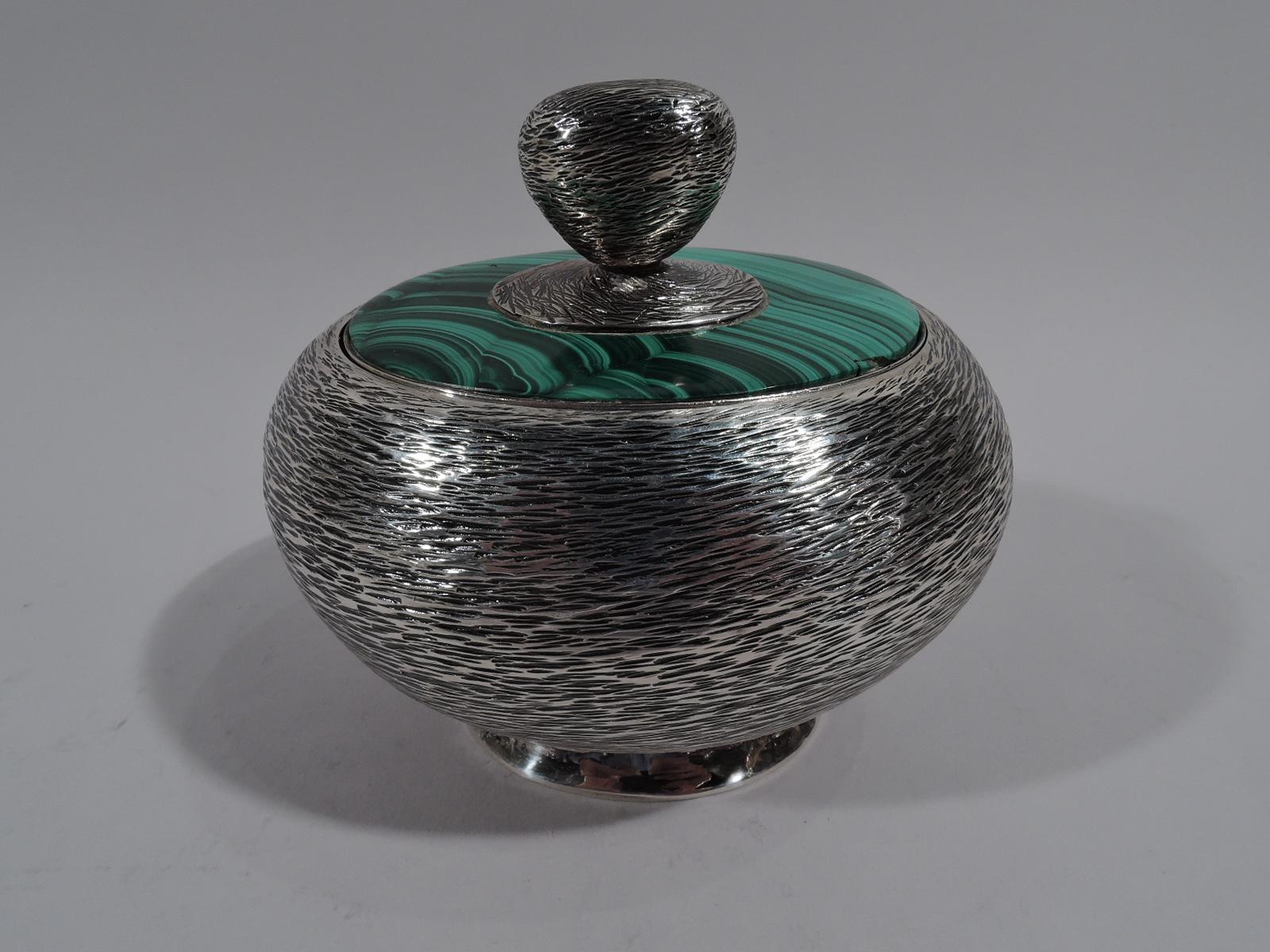 Modern sterling silver and malachite box. Made by William Seitz in New York, circa 1970. Oval with plain spread foot. Thick and tapering finial on oval ground mounted to flush malachite surround. Silver has dense and irregular striation. Interior