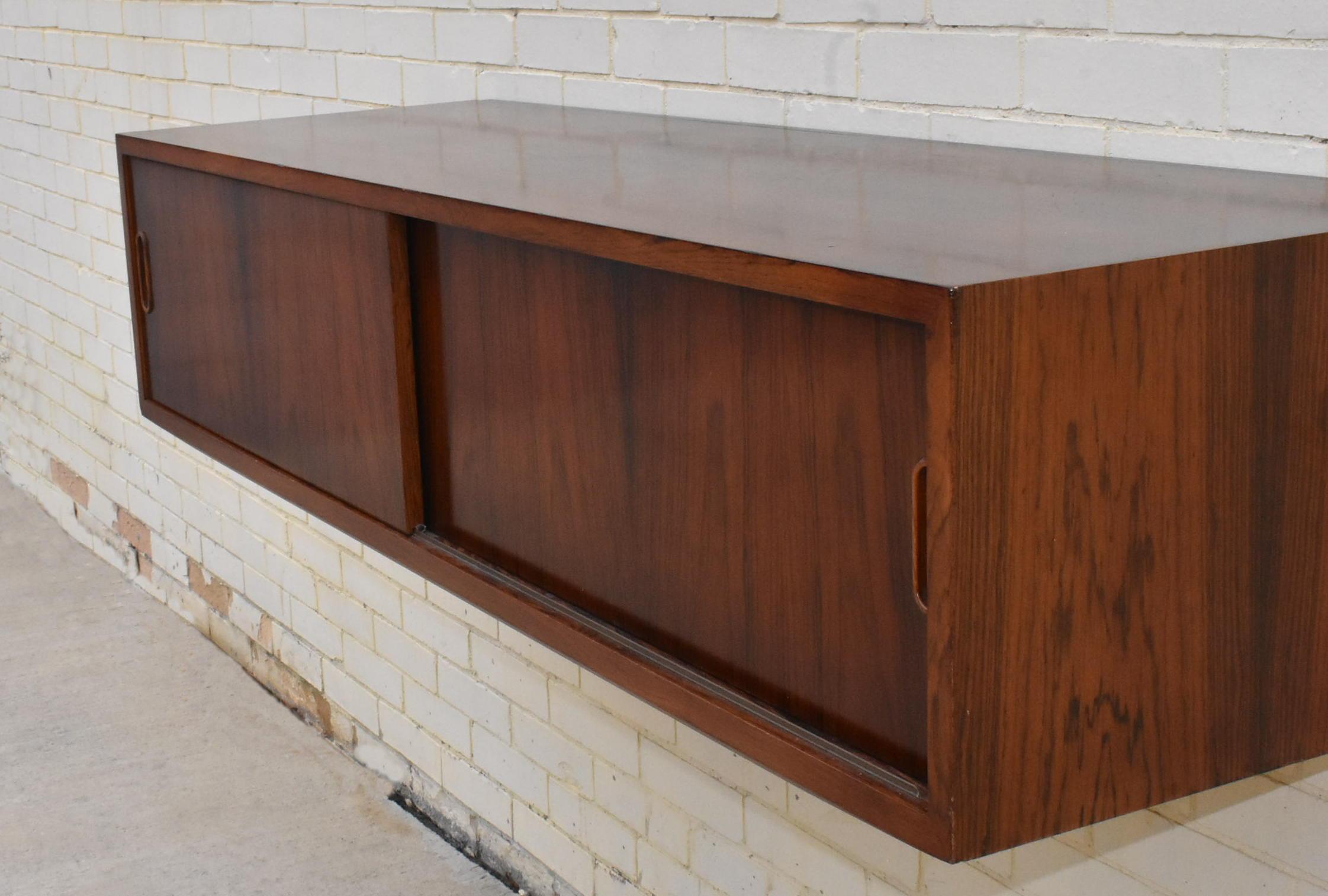 Modern rosewood Danish hanging wall credenza. Two sliding doors with wood pulls. Dimensions are 17.5