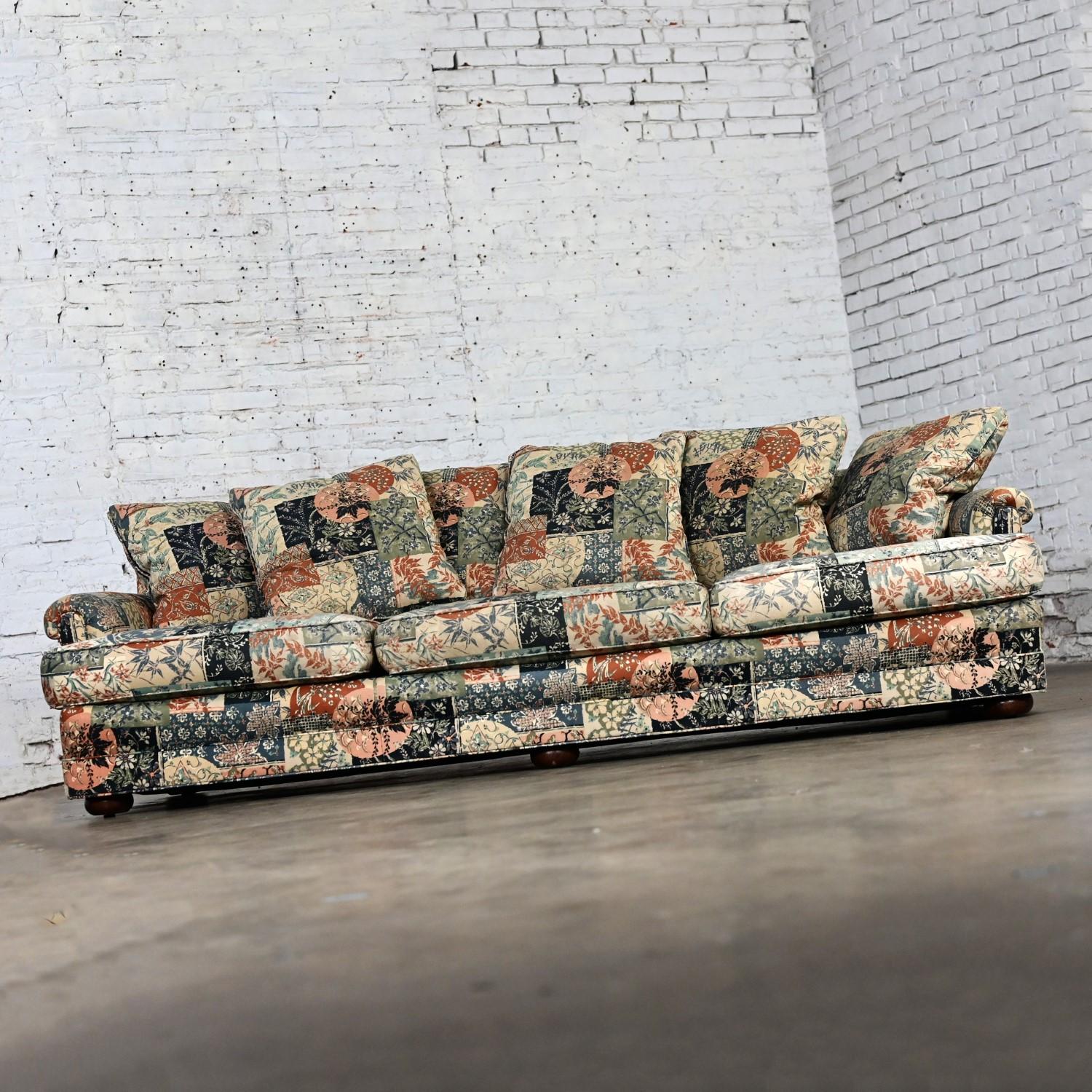 Marvelous vintage Henredon sofa comprised of 7 down filled square pillow back cushions, three loose zippered Dacron wrapped foam seat cushions, rolled arms, wood bun feet, and floral patchwork fabric. Beautiful condition, keeping in mind that this