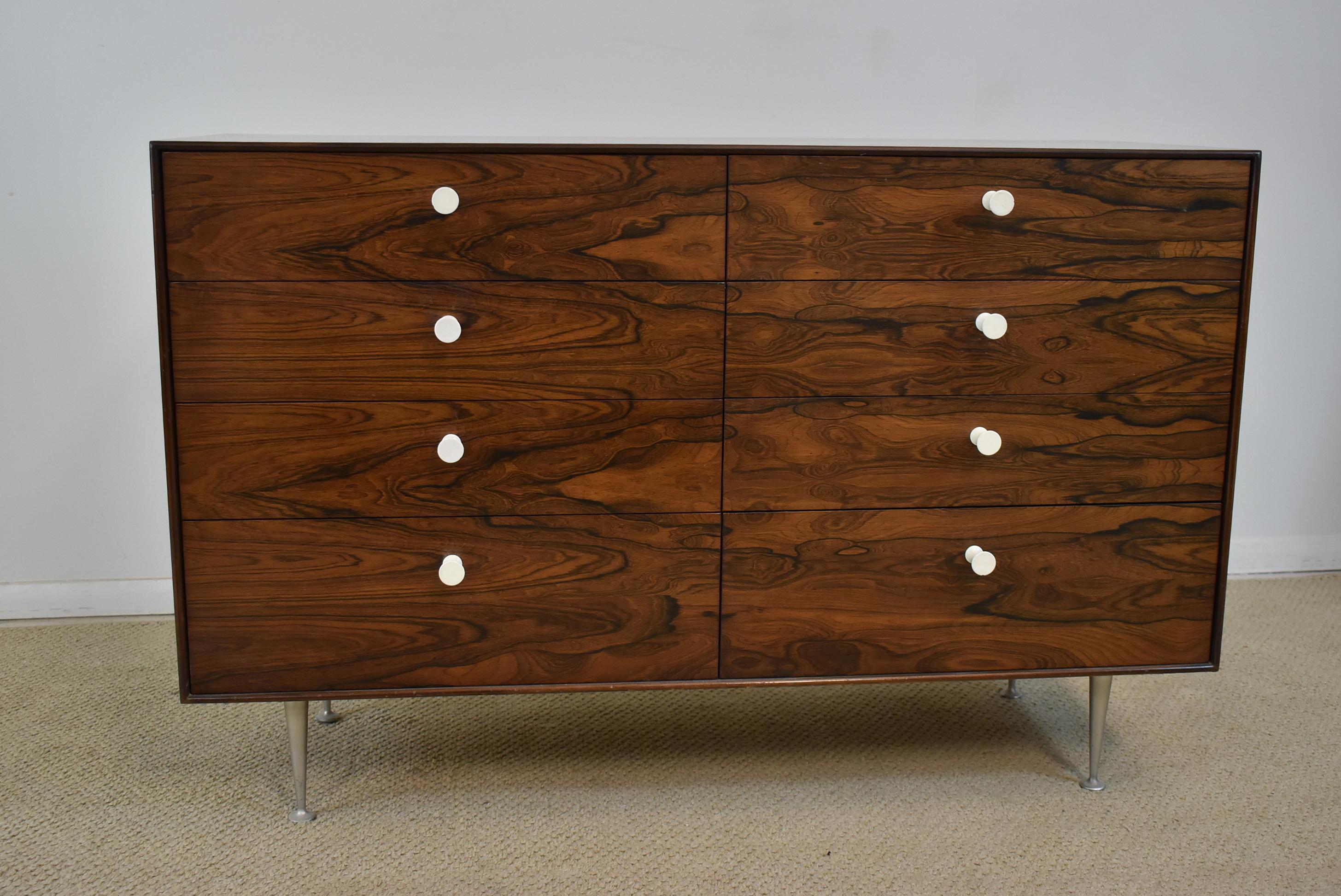 Mid-Century Modern Herman Miller thin edge eight-drawer chest designed by George Nelson design. Thin edge figured rosewood case. Sculptural aluminum legs. White stylized porcelain drawer pulls. Very good to excellent condition. 46