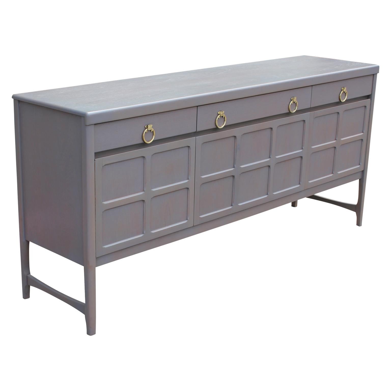 Freshly refinished sophisticated grey sideboard with brass ring handles. Centre cabinet drops down. Three drawers provide additional storage.