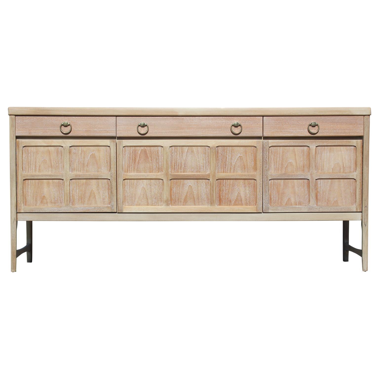 Lovely sophisticated sideboard with brass ring handles freshly restored to its natural wood finish. Centre cabinet drops down. Three drawers provide additional storage.