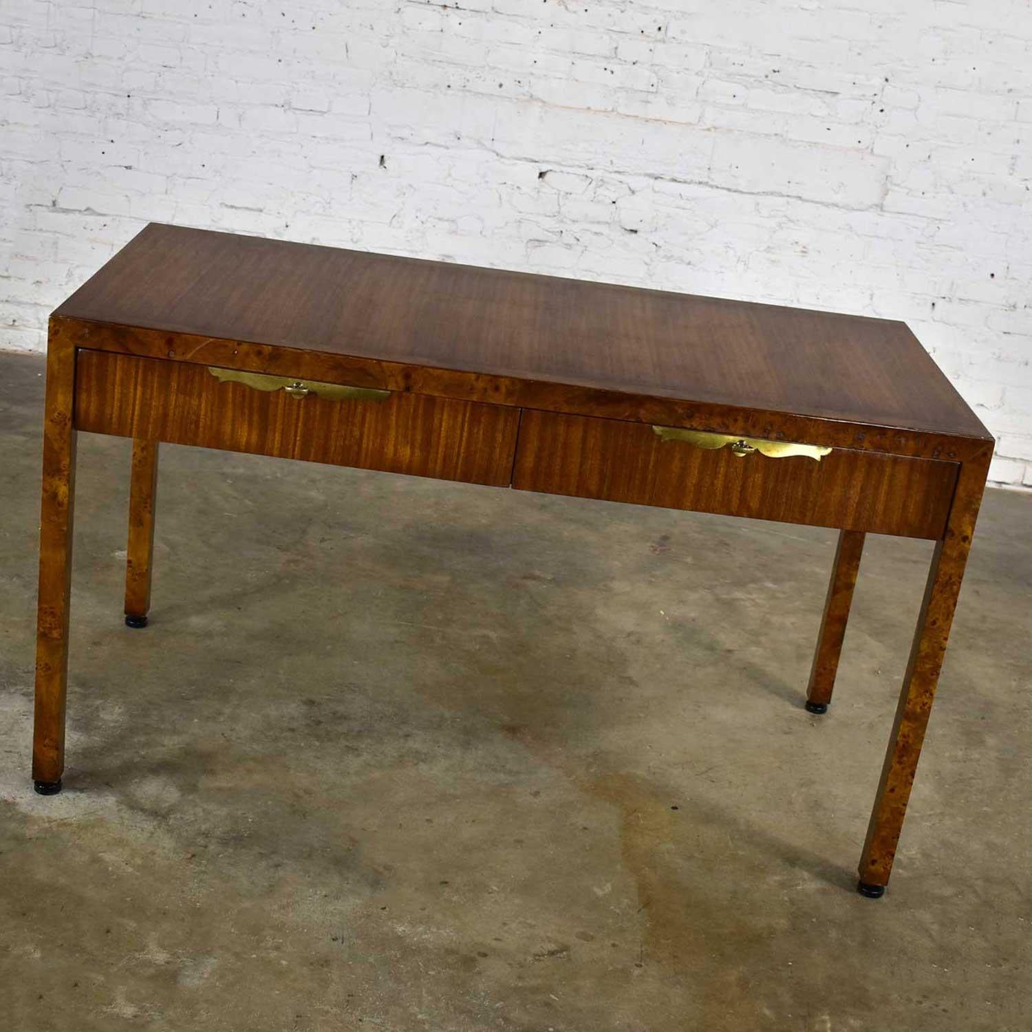 Gorgeous modern or Hollywood Regency style slender hall Parson’s style writing desk by Tomlinson Furniture comprised of walnut and burlwood, two drawers with brass escutcheon and brass plated zinc key style pulls. Beautiful vintage condition with