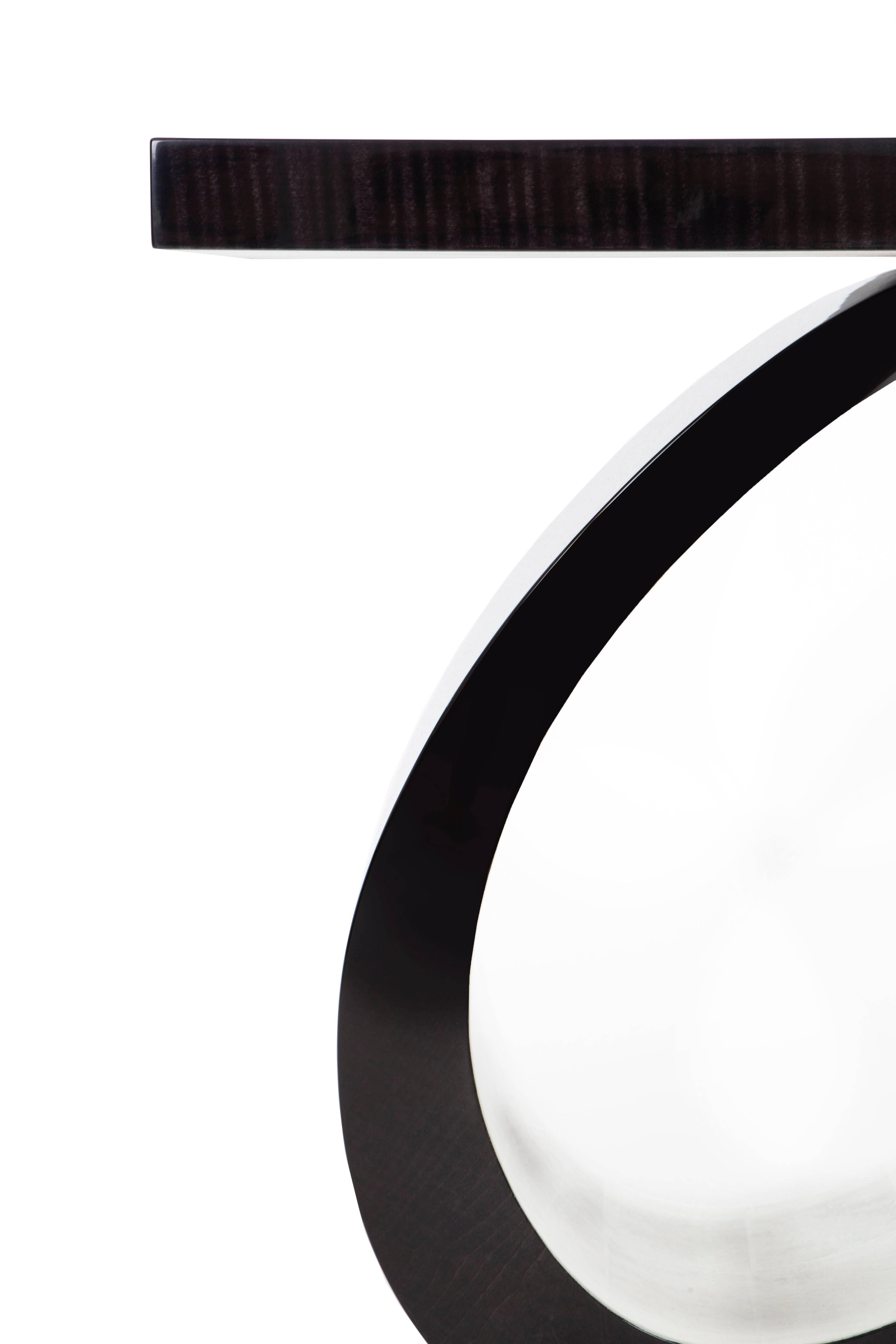 An iconic occasional table finished in sycamore black & white gold leaf.

With sleek edges and smooth curves, dark dramatic hues contrasted with lustrous white gold leaf, this is one of our most highly sought after occasional tables from the
