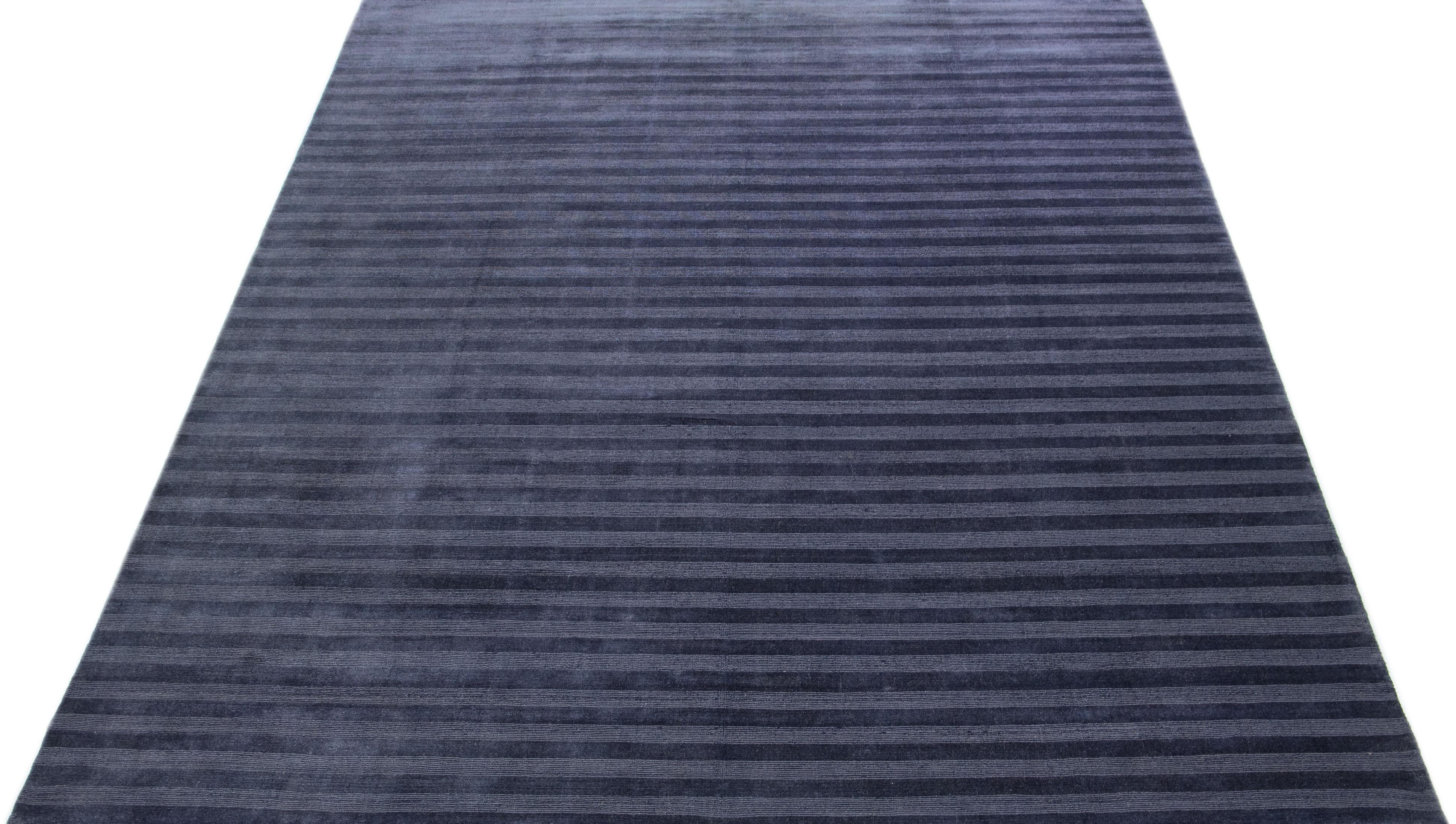 Ce superbe tapis contemporain en laine indienne est orné d'un champ de couleur bleu marine travaillé de façon complexe et d'un motif géométrique sur toute sa surface. Noué à la main dans la plus haute qualité, ce meuble ne manquera pas de faire