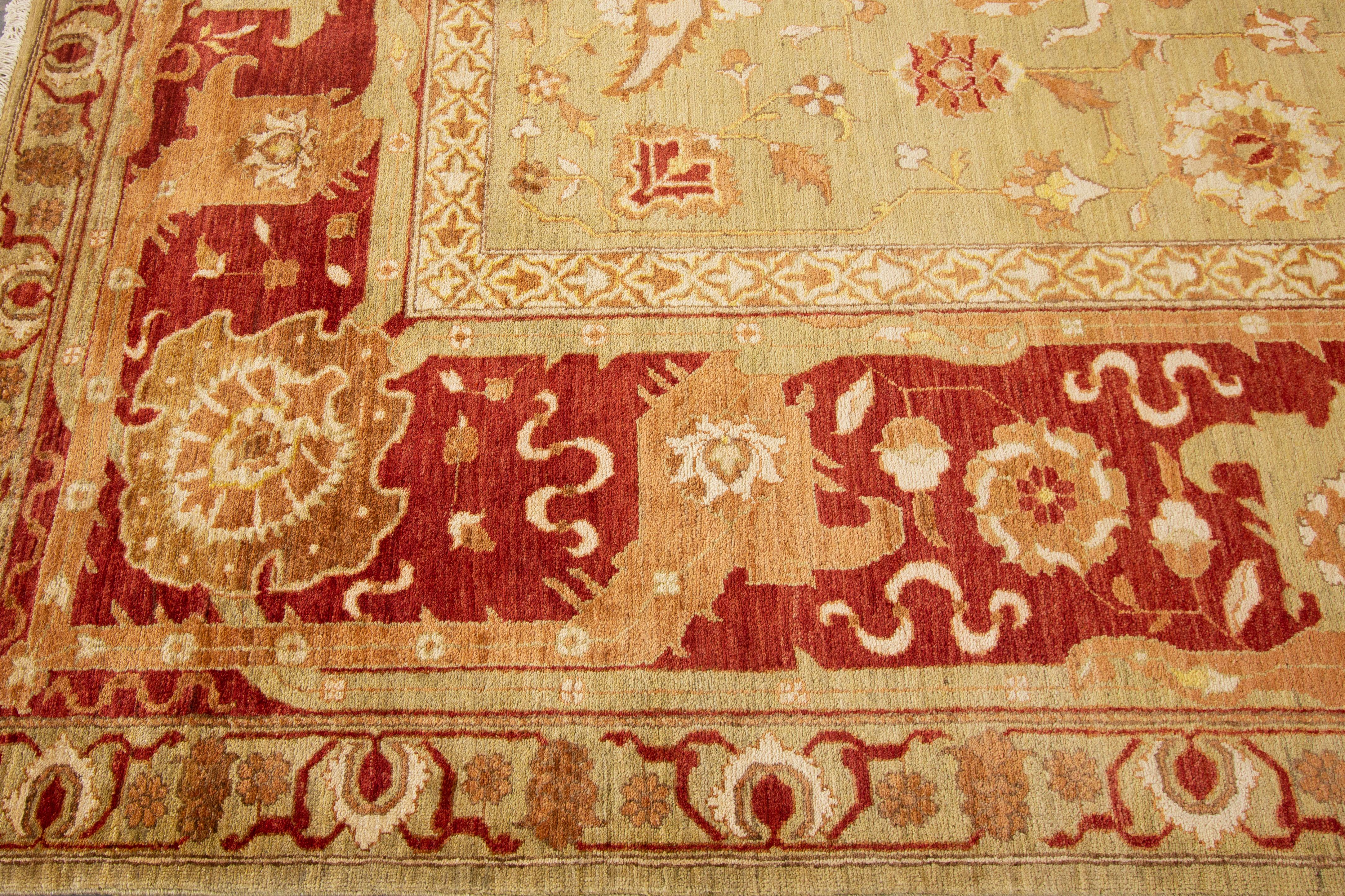 Ein zeitgenössischer, handgeknüpfter indischer Wollteppich aus Peschawar mit einem warmen, gelblich-beigen Feld, das mit einem komplizierten, floralen Allover-Muster verziert ist. Die leuchtenden Rot-, Orange-, Elfenbein- und Gelbtöne unterstreichen