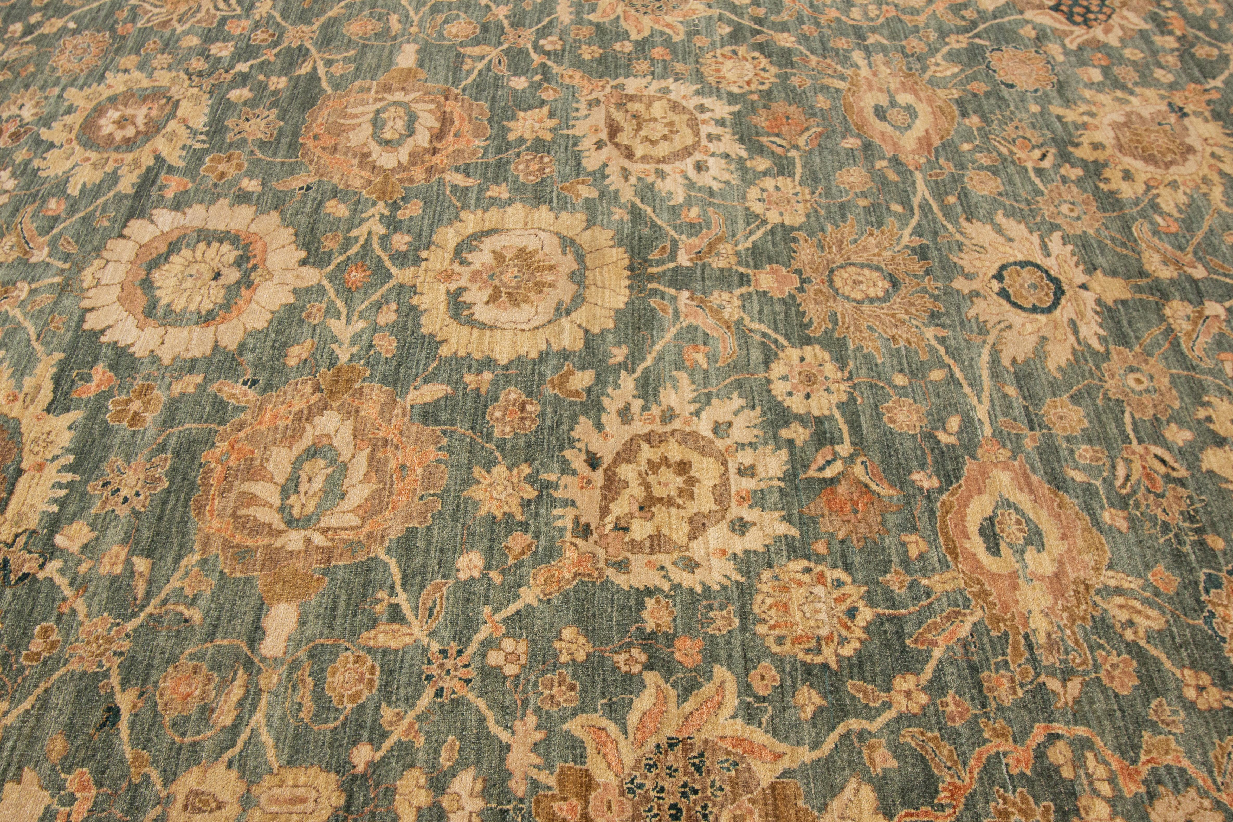 Scopri la bellezza di un tappeto indiano contemporaneo in lana fatto a mano proveniente da Peshawar. Questo squisito pezzo presenta un campo verde vibrante delimitato da una cornice beige, ornata da intricati motivi floreali in ricche tonalità di