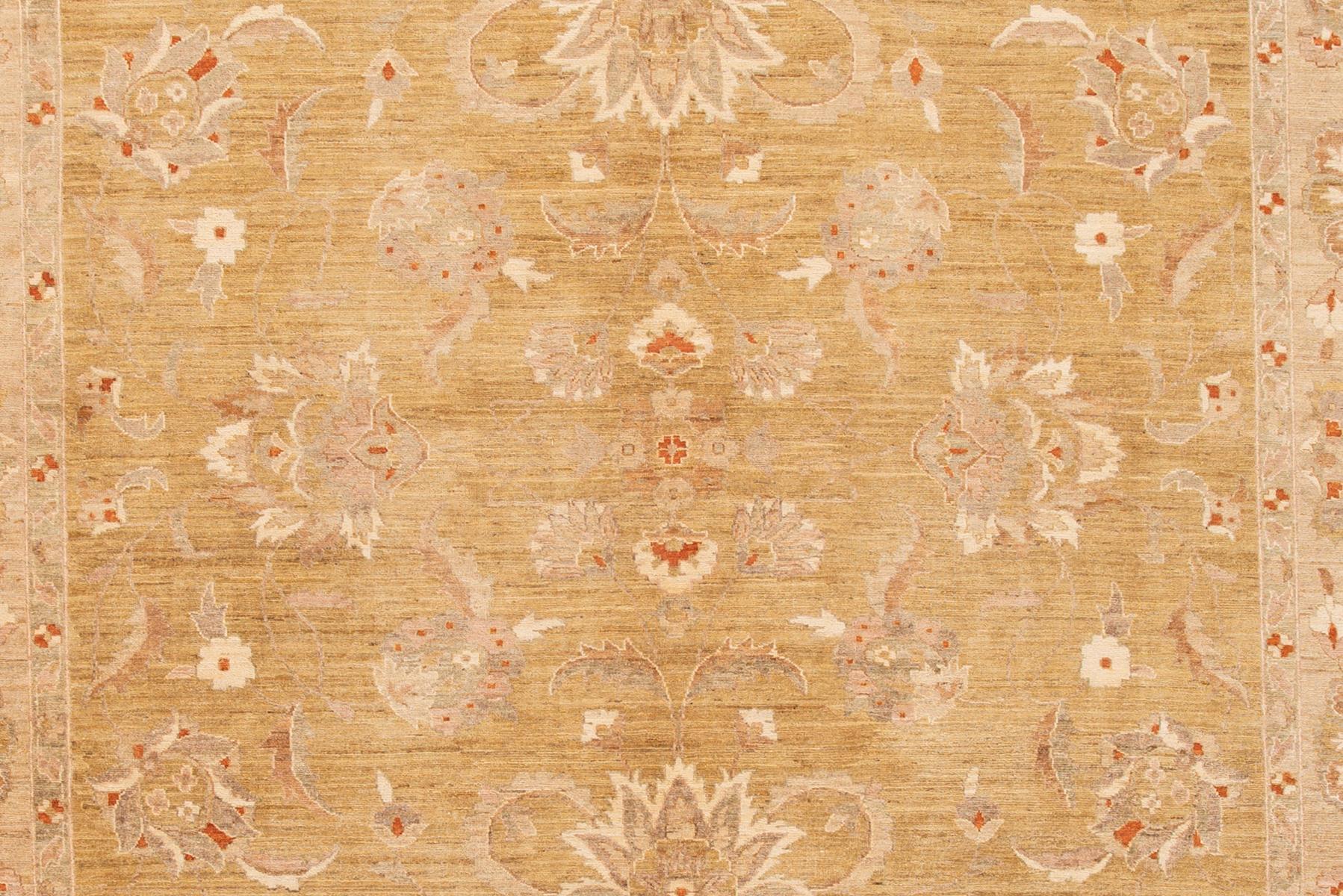 Modern Indian Peshawar hand-knotted wool rug with a tan color field. This piece has gray, beige, and rust accents in an all-over floral design. 

This rug measures 10'1