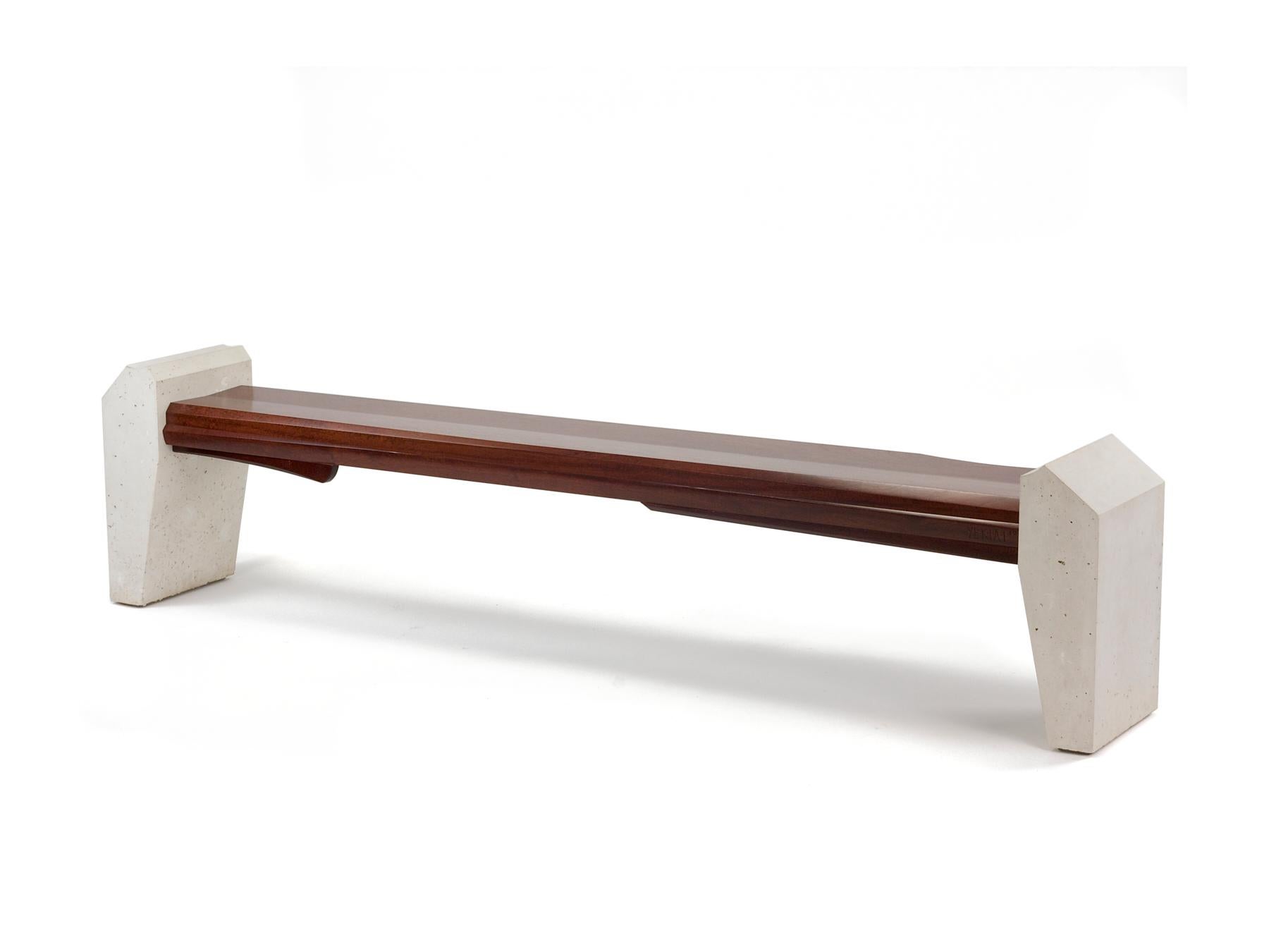 Two white cast concrete legs embrace a sculptural bundle of oxidize a Sapele wood. The wooden seat is elegant, robust and delicate at the same time. Much of this comes from the narrowness of this bench and it's length. It's like a breath of fresh