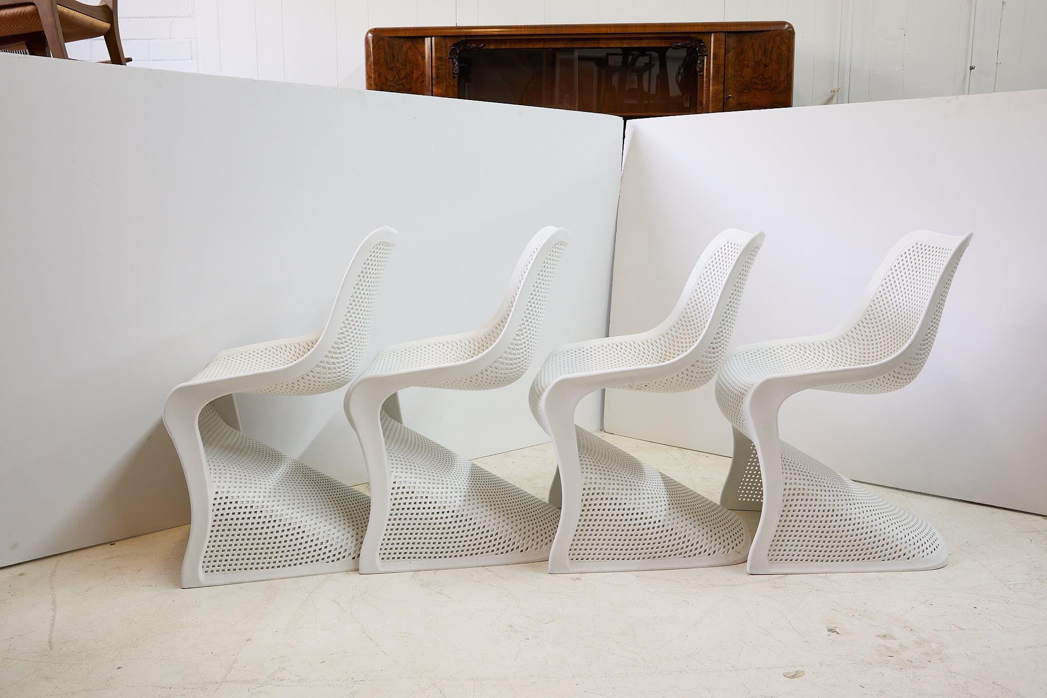 The Bloom chair by Compamia features a contemporary, cantilevered design with commercial strength. The white chairs are made from marine grade resin with fiberglass air molding technology while the pierced lattice back allows for comfortable