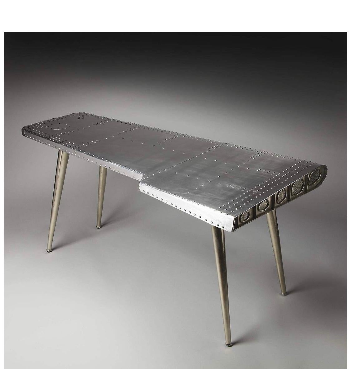 Modern industrial silver “airplane” wing writing desk table for the home or office.

Modern, eye-catching design adds a sleek look to your home or office
Made from very high-quality MDF wood, iron and aluminum
Strong and sturdy
Very easy to clean