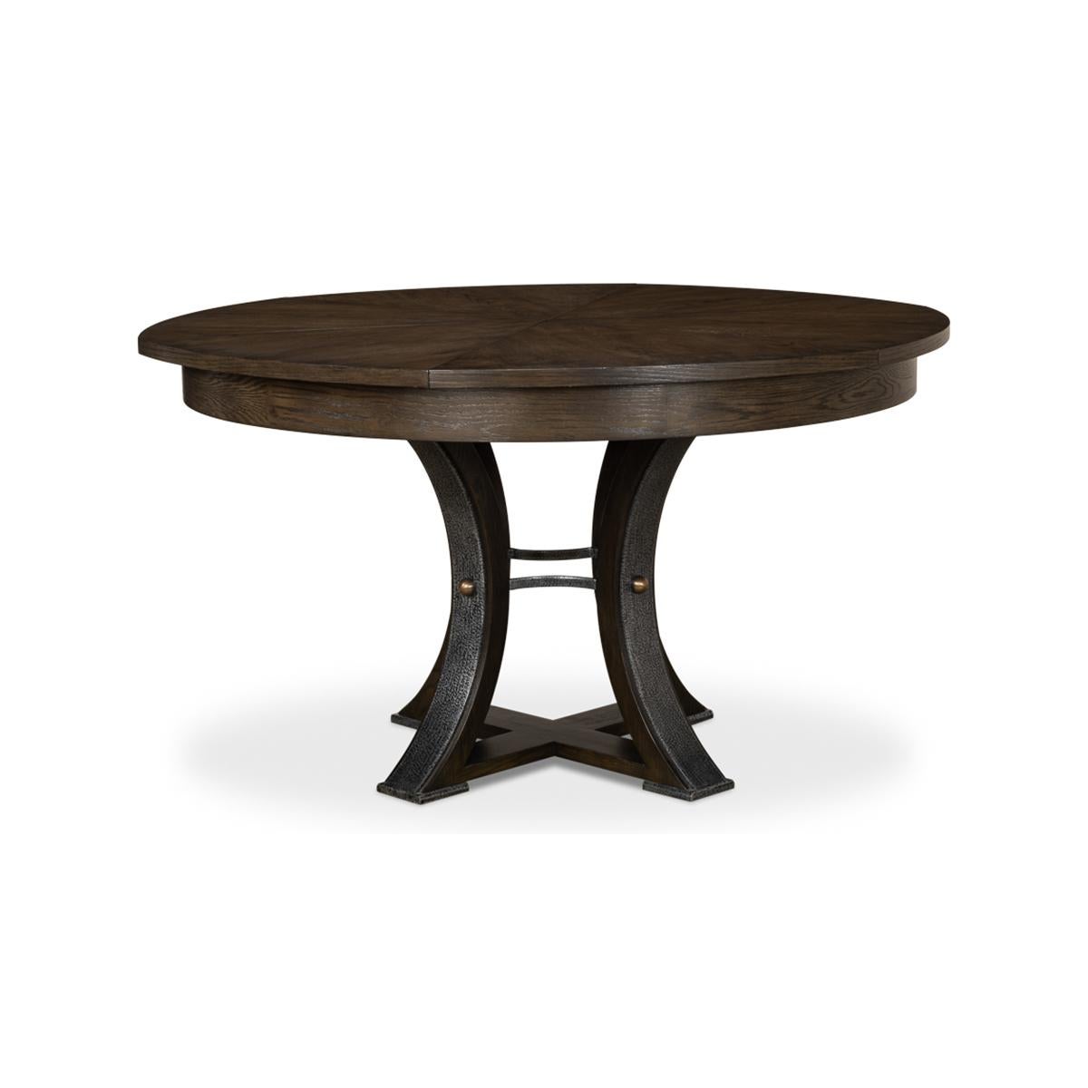 A modern industrial style jupe round extending dining room table. Wire brushed oak top with gunmetal iron accents to the simple geometric form base. The table opens and extends to 70