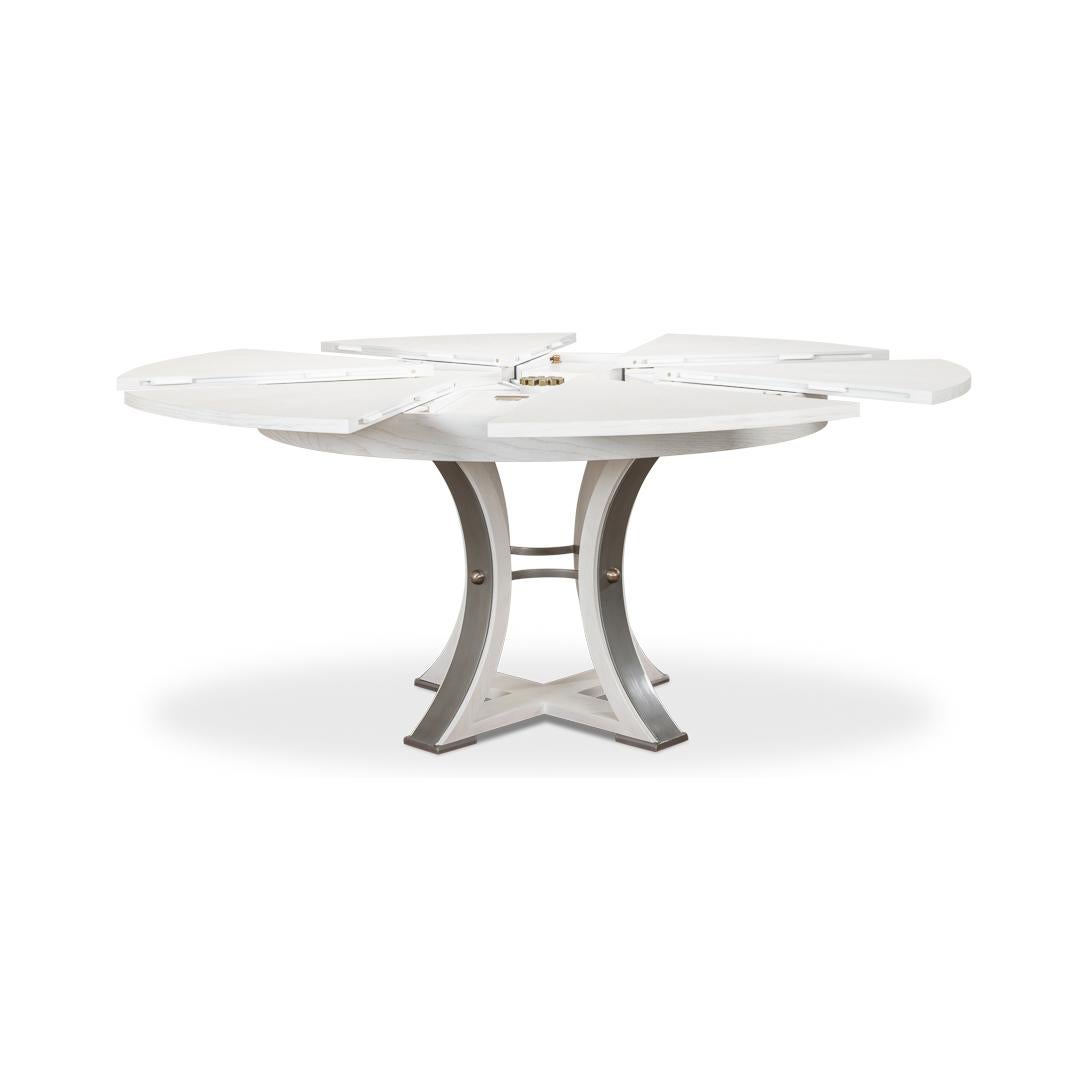 A modern industrial style round extending dining room table. Wire brushed oak top in our working white finish with gunmetal iron accents to the simple geometric form base. The table opens and extends to 70