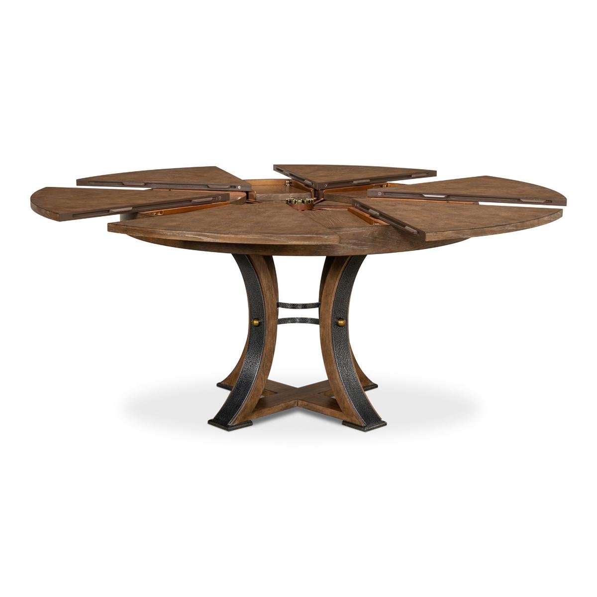 A modern industrial style round extending dining room table. Wire brushed oak top in our Light Mink finish with gunmetal iron accents to the simple geometric form base. The table opens and extends to 70