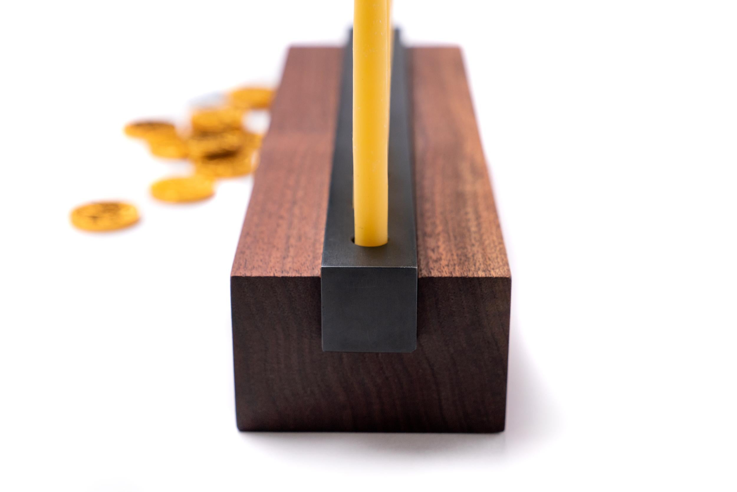 Display this modern industrial menorah in walnut wood and steel to celebrate eight days of Hanukah miracles. Made with solid urban wood, so it's eco-friendly. Steel has a black patina. Clean lines and streamlined design makes it fit on a tabletop or