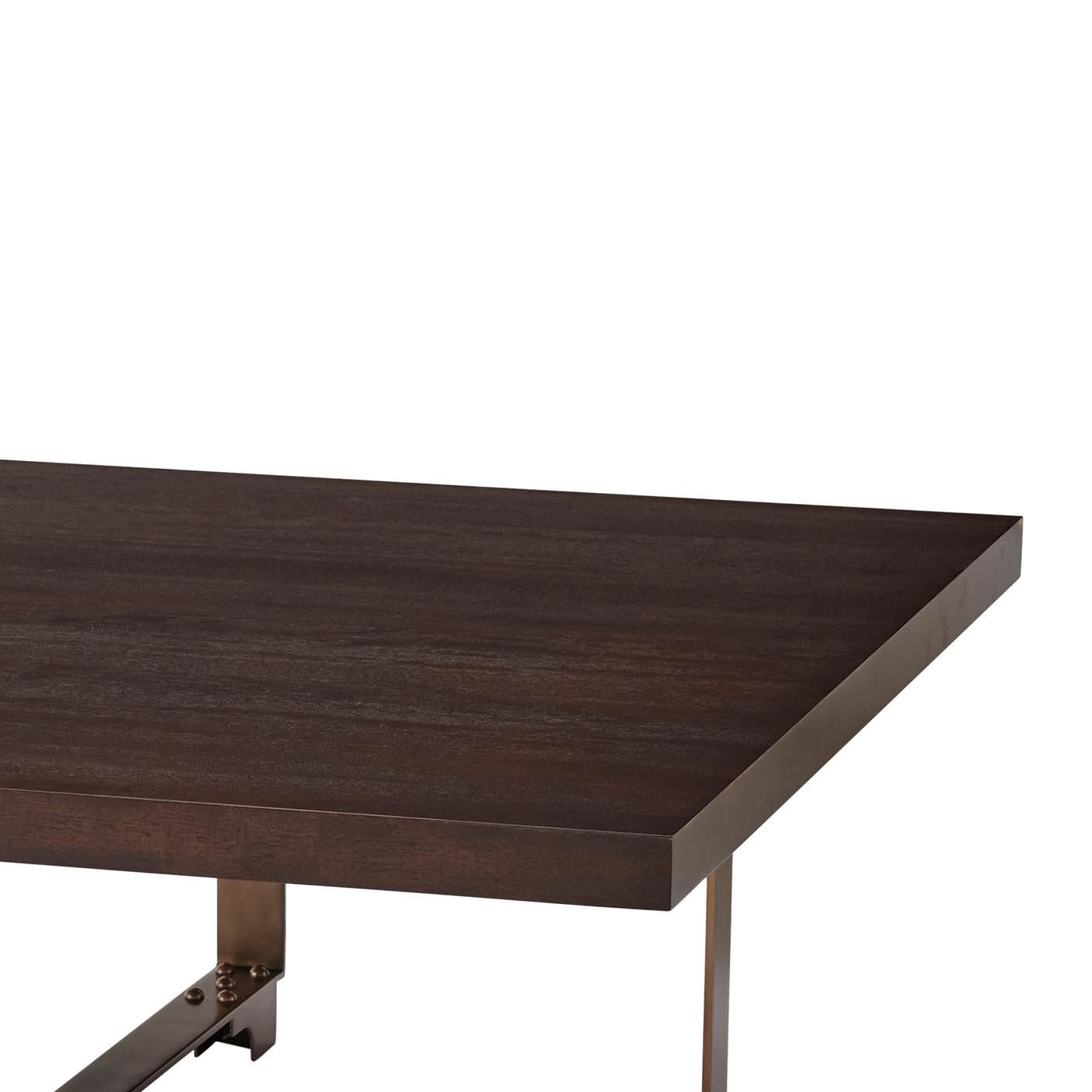 Modern industrial square cocktail table with a mahogany veneered square top, the base, a studded steel monolith bound by bracket supports.

Dimensions: 48