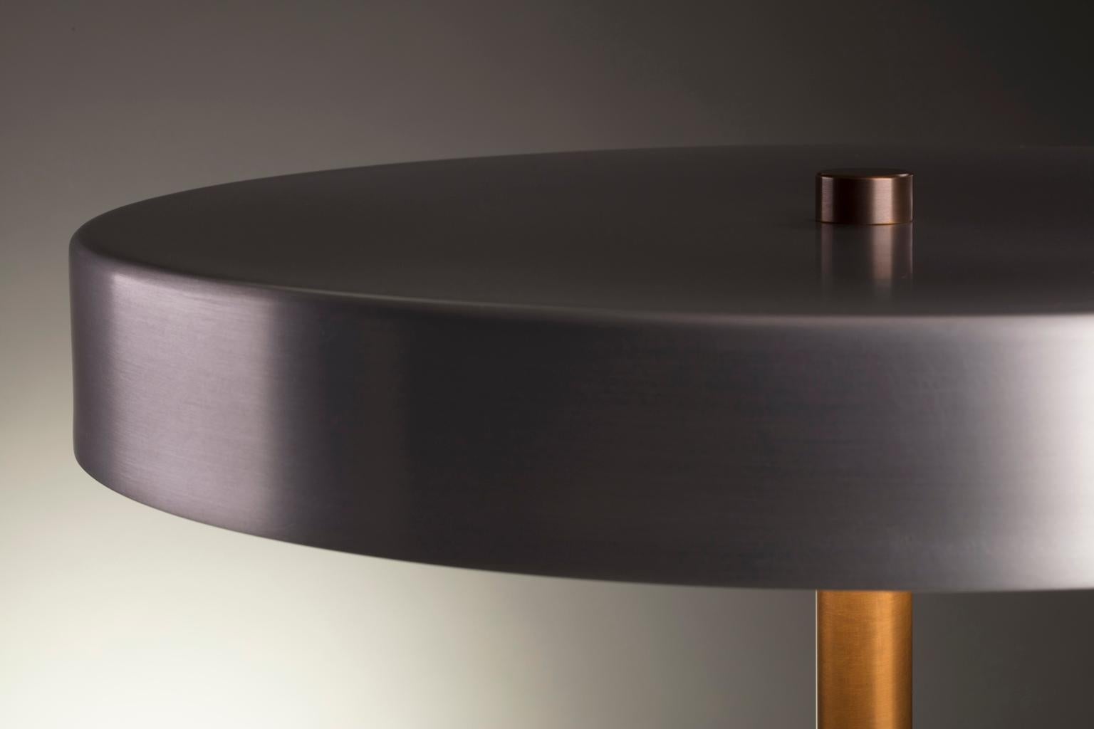 Collection I: Disc lamp in burnished aluminum.

Available in a matte black or softly burnished finish, the shade of the disc lamp can either fade into its surroundings or catch light to emphasize its refined form.

The integrated dimmable LED