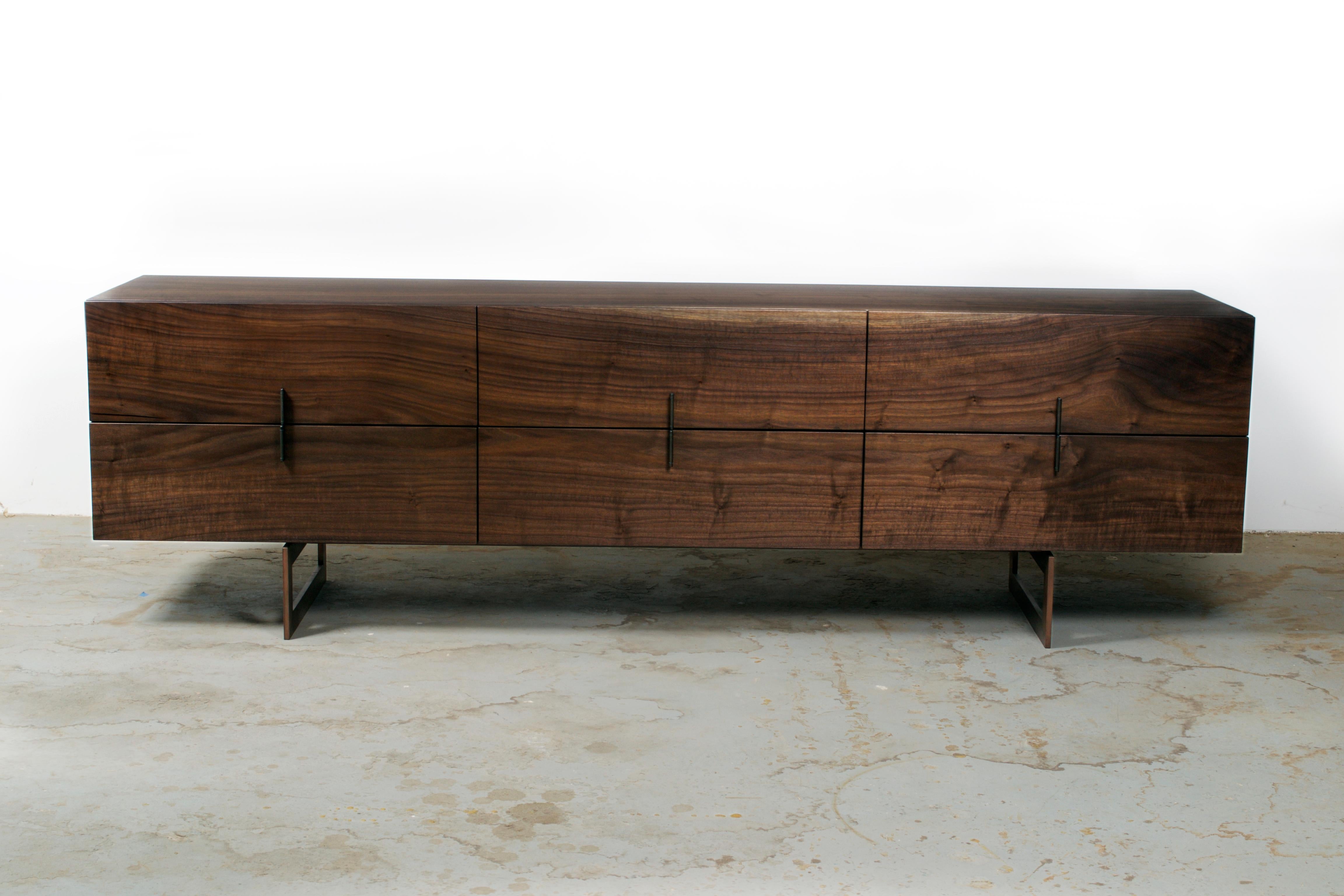 Made from sequentially cut pieces of wide solid walnut this long, low, 6-drawer dresser was an exercise in matching grain. Drawer fronts are a bookmatched mirror image of the top, with the grain flowing seamlessly over bookmatched miter folded