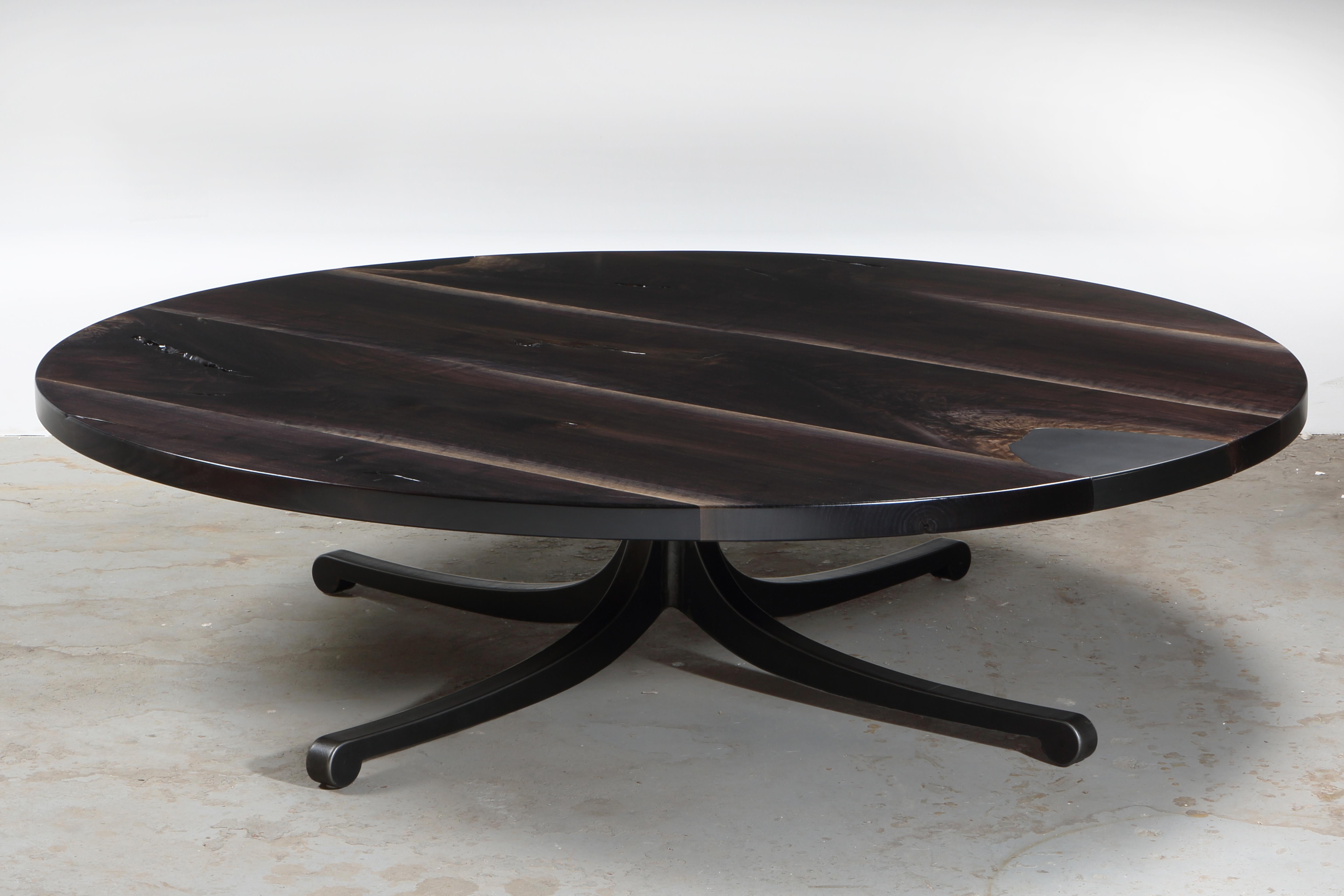 A single slab of highly figured walnut lends a celestial effect to the top of this exquisite serif coffee table. Grain matched steel inlay, with removable steel plate revealing hidden storage. Signature serif leg, shown in raw flame cut finish.