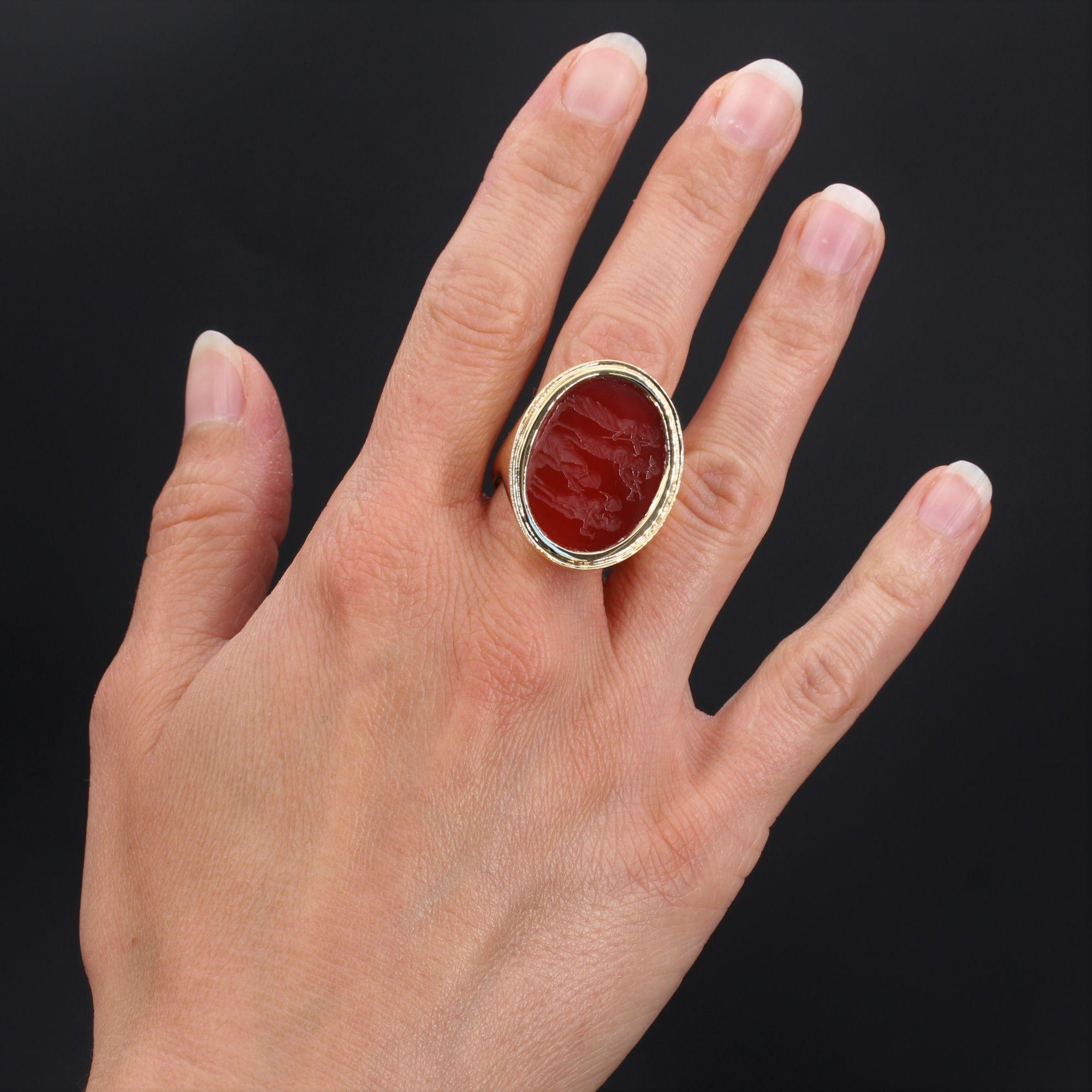 Ring in 18 karat yellow gold, eagle head hallmark.
Imposing man signet ring, it is closed set of an intaglio on carnelian representing a scene of Bacchus, surrounded by a throat. The start of the ring is wide and curved, and tapers to the hollow of