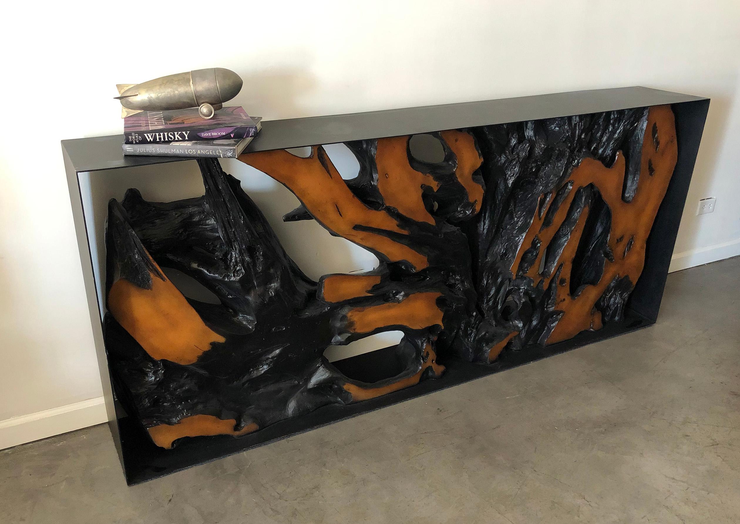 A stunning find, this console table brings warmth and modernism to any space. This piece features a faux cast root / tree specimen encased within a black, modern, iron frame.