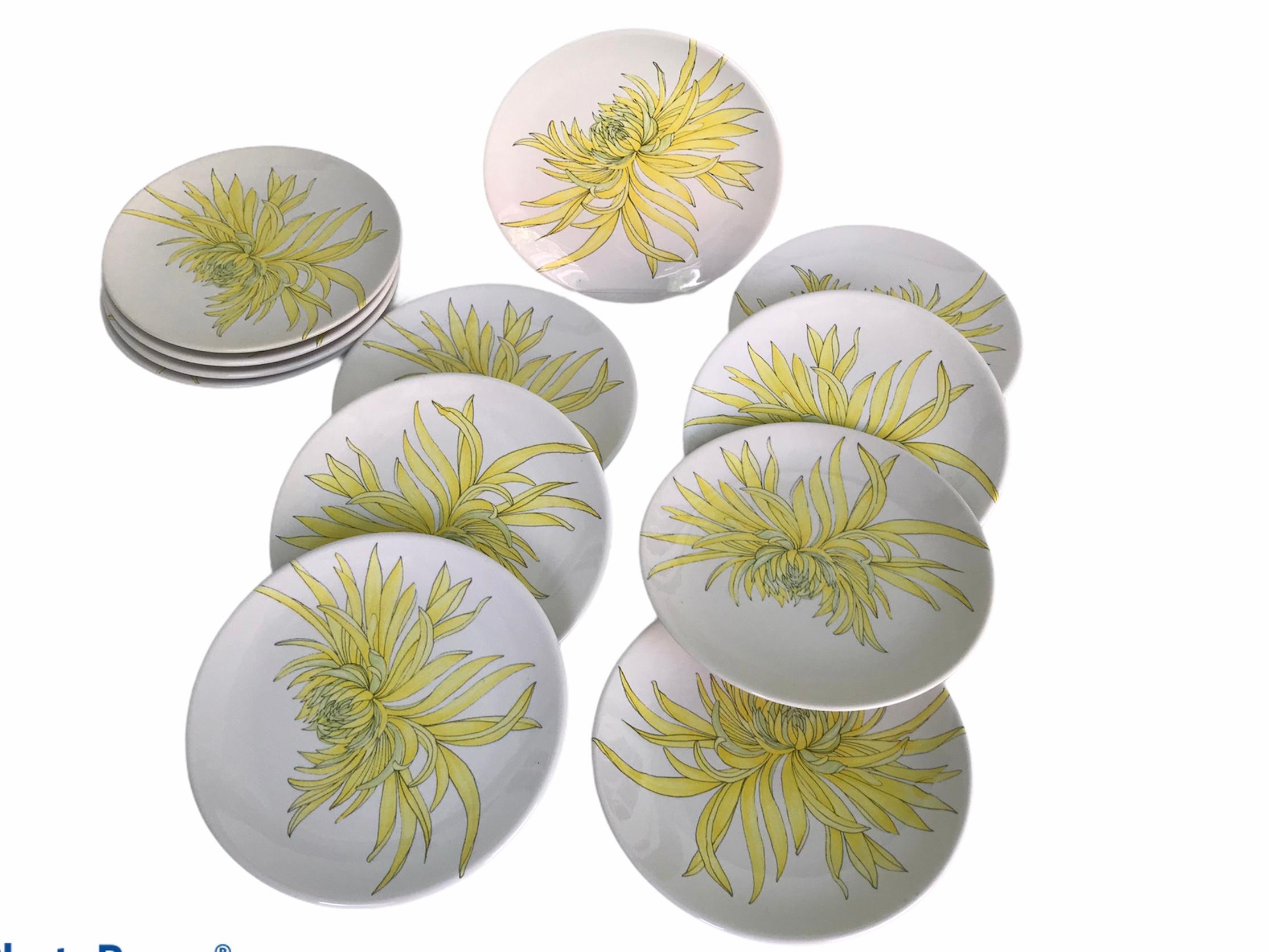 An early 1960s set of 12 hand painted salad /dessert plates by Ernestine, Salerno, featuring a Chrysanthemum design in yellow, orange and green on an white background. All in excellent condition, never used. On the bottom signed E (rnestine) Italy