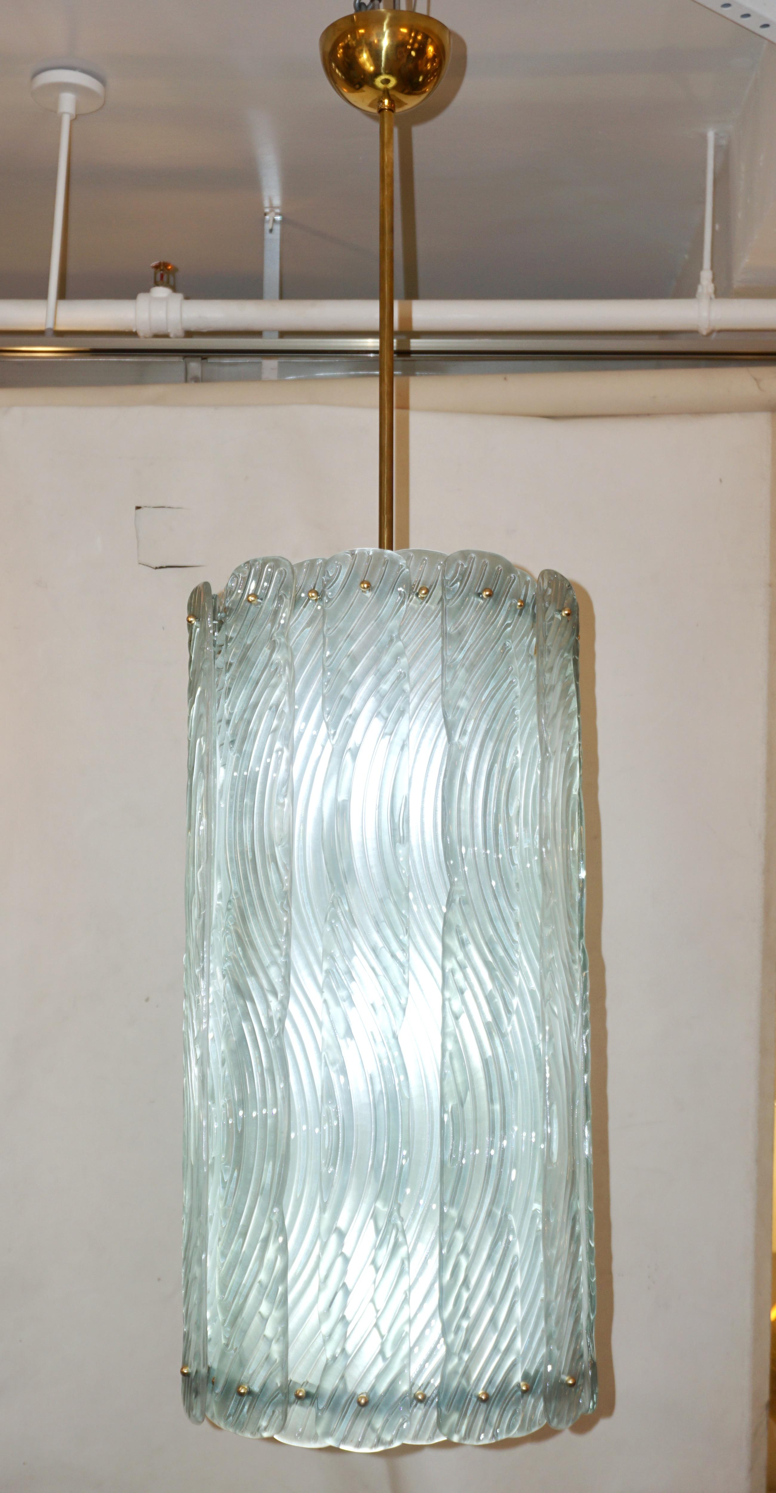 Contemporary Italian Art Deco design huge round pendant chandelier, entirely handcrafted. This light fixture is composed of a handmade brass structure supporting textured frosted Murano glass curved bands with a sophisticated green azure blue color,