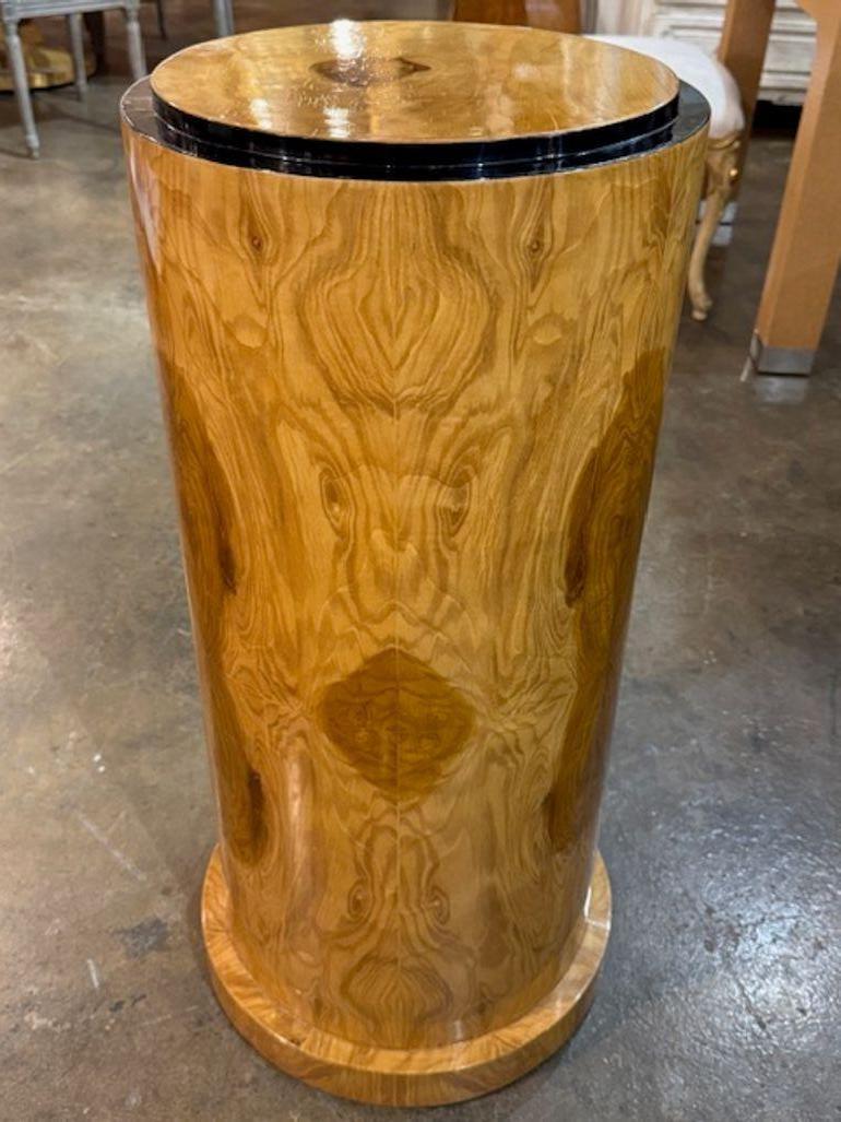 The product is a set of modern Italian Art Deco style wooden pedestals made from burl walnut veneer. These pedestals are perfect for displaying decorative items or serving as a base for accent pieces in a home.  The sleek and elegant design adds a