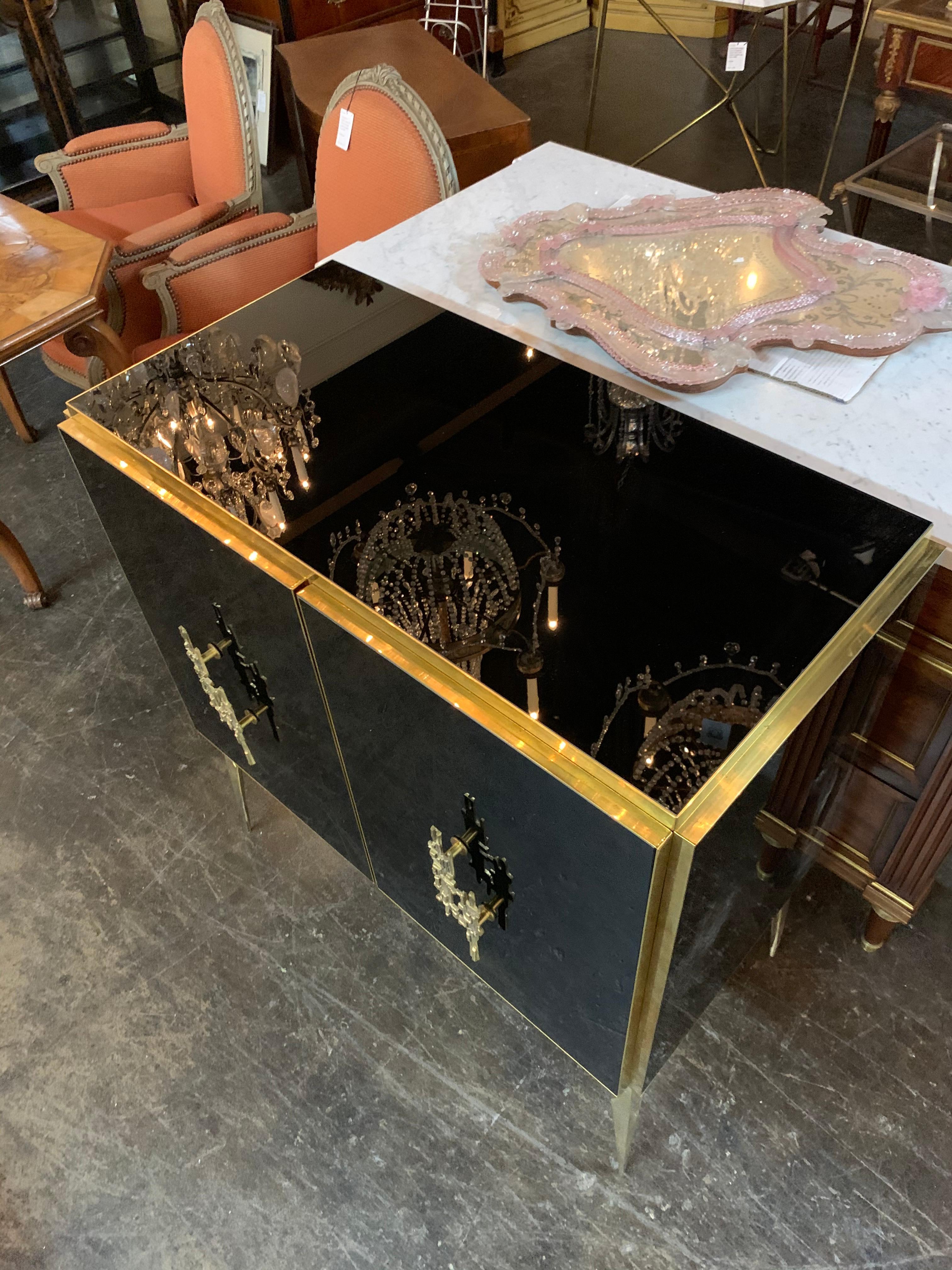 Stunning modern Italian black glass and brass side cabinet. Glistening black glass with lovely brass accents. Very fine quality and an excellent piece for a high end design. Exquisite!