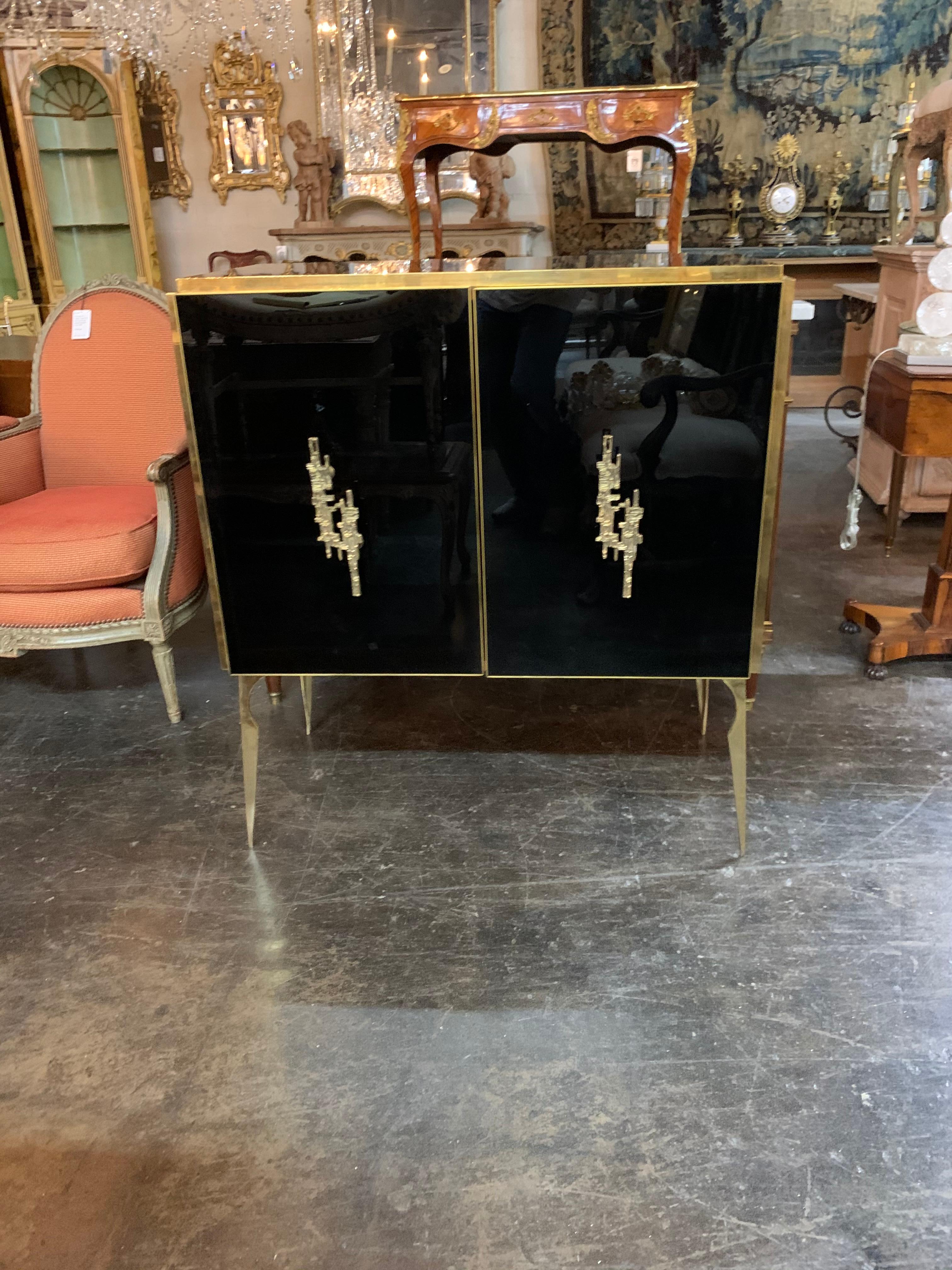 Extremely elegant modern black glass and brass side table. Super polished look for an upscale home. Beautiful brass handles and a shelf inside as well. Superb!