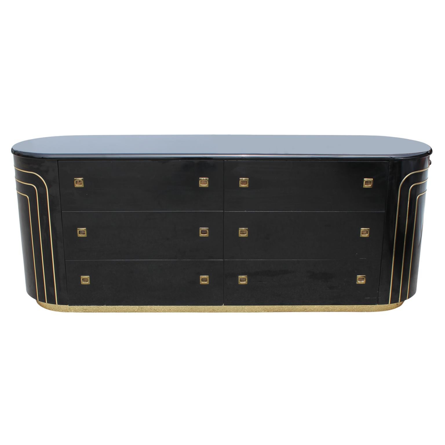 Lovely modern black lacquer rounded dresser with eight drawers featuring a brass base and brass detailing.