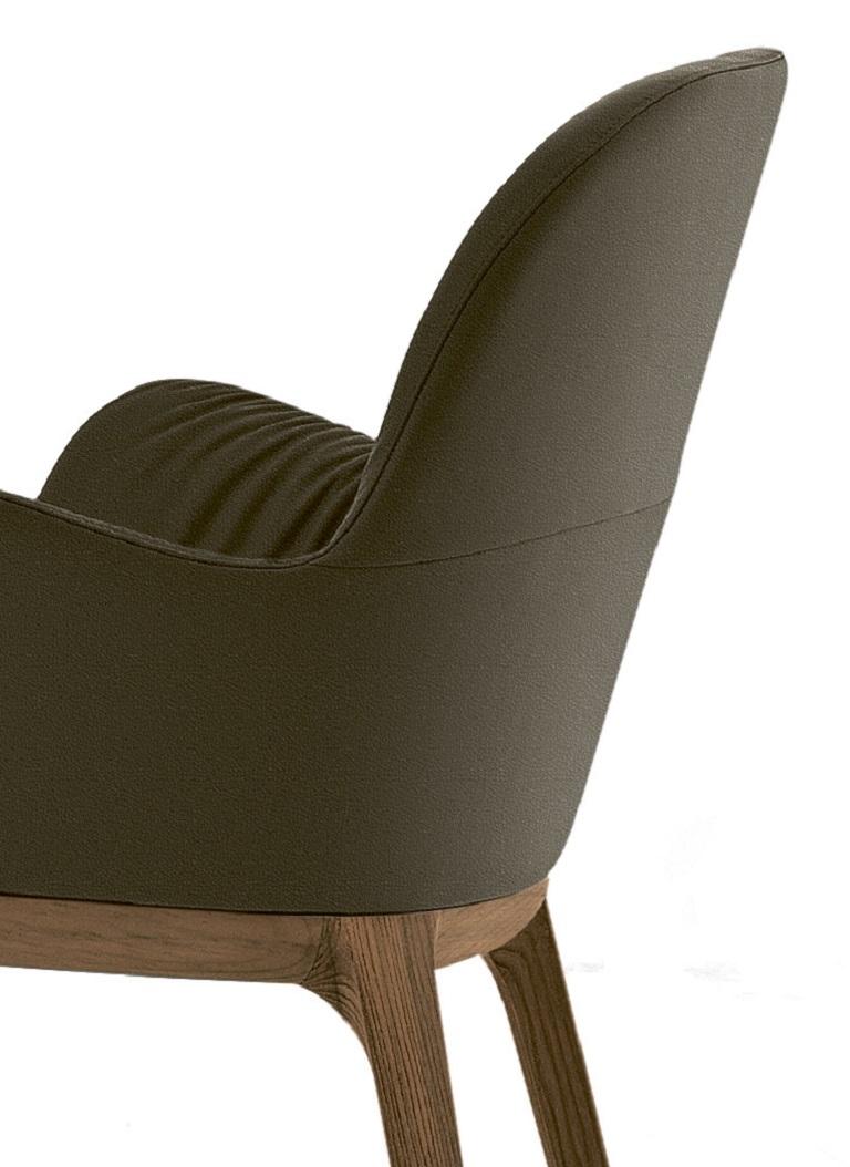 Designed by Pocci&Dondoli, this chair is part of a family of seats that are rich of fashion and characterised by an elegant design in each detail. The wrinkles of seat and back are softly upholstered. The frame of this chair is in Walnut Solid wood.