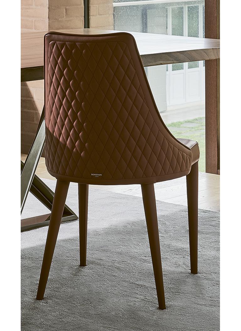 Le style classique et le design moderne se mélangent de manière exceptionnelle, donnant vie à une chaise au caractère sophistiqué qui éveille une agréable nostalgie du passé. Le dossier matelassé ajoute une touche de style et de raffinement à