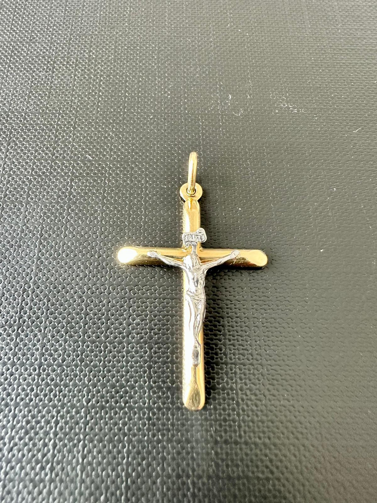 This simple and elegant modern crucifix is in 18kt yellow and white gold and it's manufactured in Italy. 

The term crucifix refers to a cross with Jesus on it. The particularity of this crucifix lies above all in the relief work carried out on the