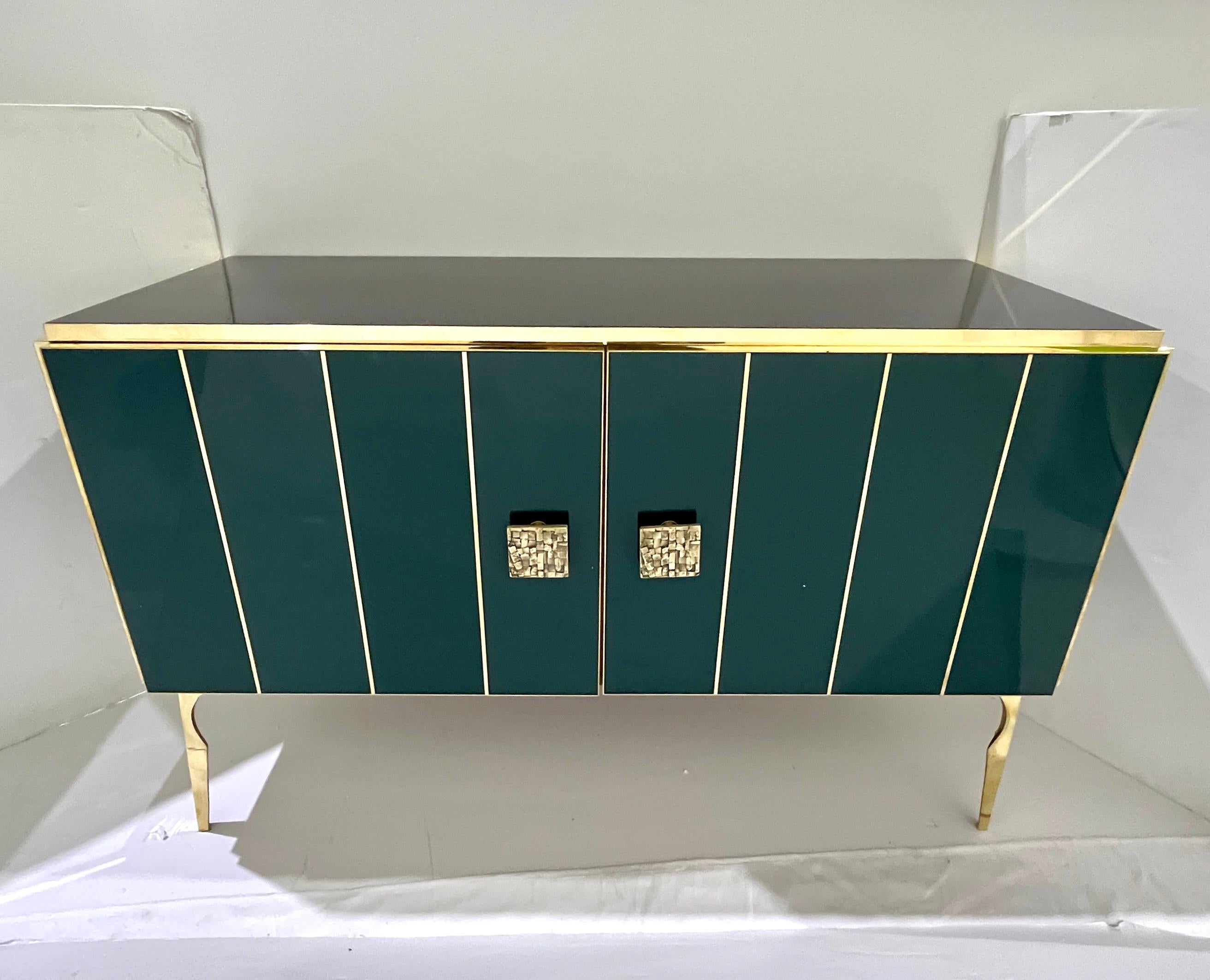 Bring glamour to your interior with this bespoke customizable modern 2-door cabinet, entirely handcrafted in Italy, with a Hollywood Regency feel. The surround is decorated with art glass in a striking hunter bottle green color, striped vertically