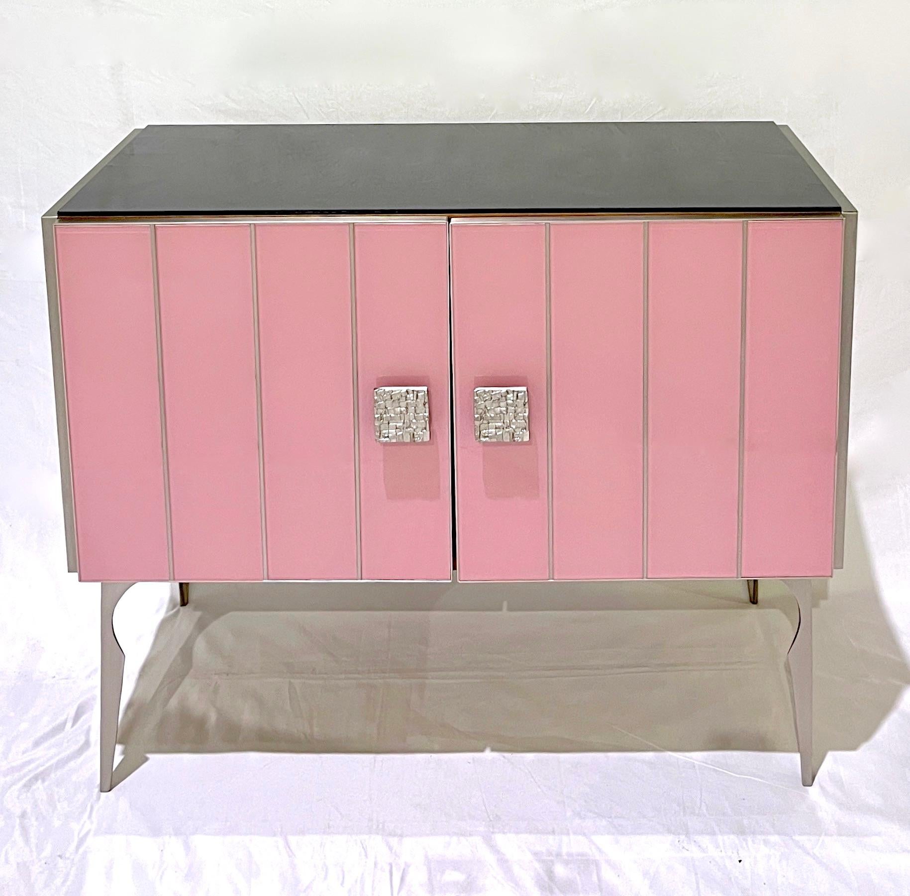 Bring glamour to your room with this bespoke customizable modern cabinet, entirely handcrafted in Italy, with a Hollywood Regency feel. The surround is decorated with art glass in a striking soft pink salmon rose color, striped vertically with satin