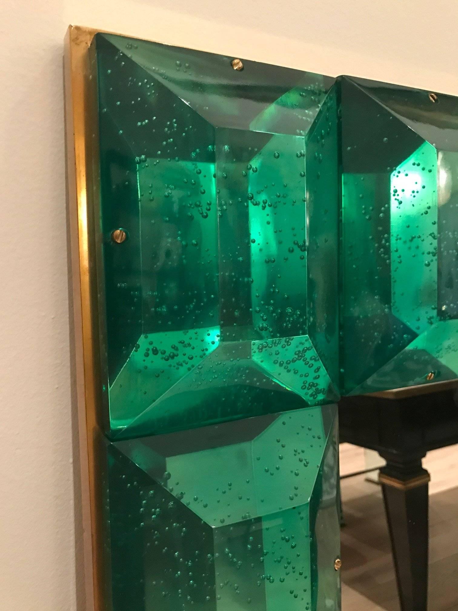 Large emerald green Murano glass and brass frame mirror.
Each emerald green glass block has a highly polished diamond faceted cut pattern with air inclusions throughout. Can be displayed either horizontally or vertically.
Weight is 158 lbs.

 