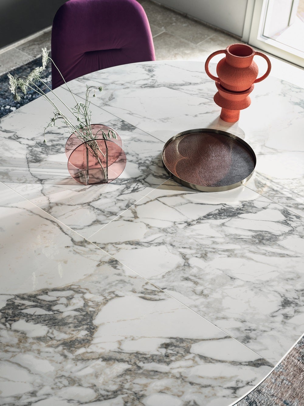 Designed by Pocci&Dondoli, this table is characterized by a harmonious twist of sinuous arches, that outlines its unique base. The round top and butterfly leaf extension are made up of the unique material SuperMarble, which is composed of 6mm of