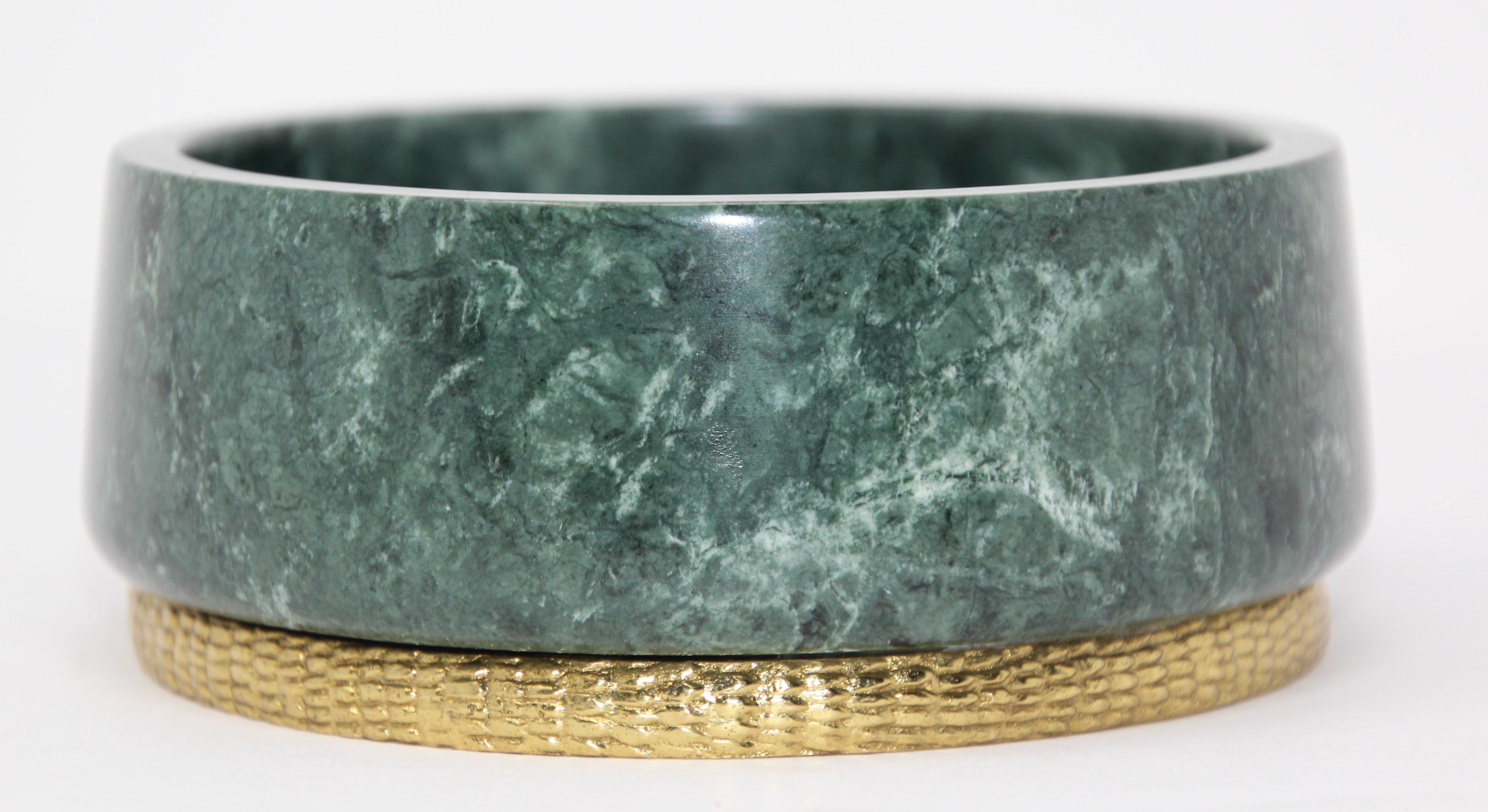 Michael Aram modern green marble footed bowl catchall with brass.
Green marble Michael Aram Rainforest centerpiece bowl featuring raised gold-tone brass border at base and brand stamp at underside
Use as a catchall or decorative bowl. 
Jade green