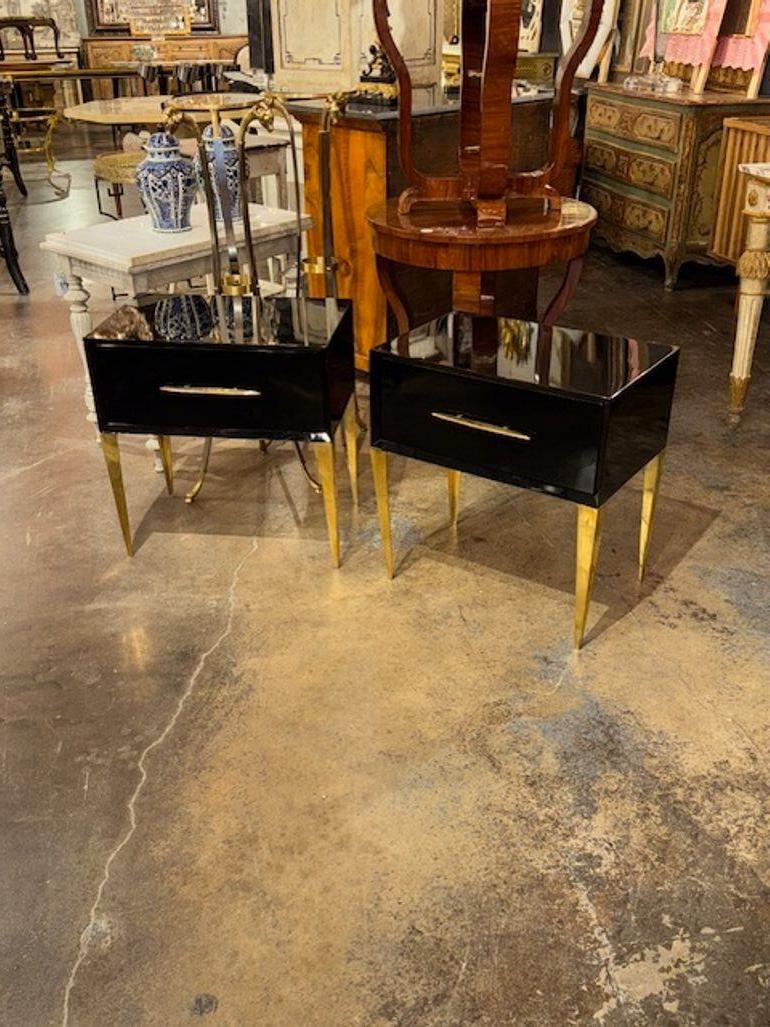 The modern Italian side tables feature a sleek design with a high gloss black lacquered finish, giving them a sophisticated look. The tables are accented with brass handles, and legs adding a touch of elegance to the overall aesthetic. These tables
