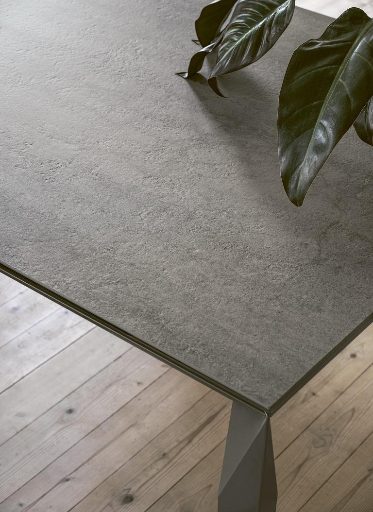 Designed by Toshiyuki Yoshino, this extendible table is characterized by the diamond-cut facetings of its legs, giving lightness and elegance that mix perfectly with the stability and strength of aluminum. The top is in Savoia Grey Superceramic, a