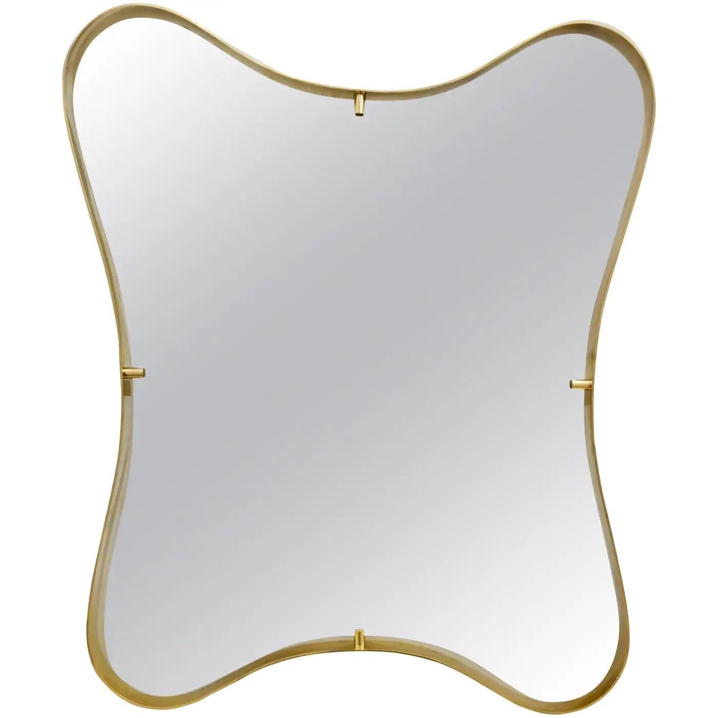 Contemporary Italian modern design mirror with elegant curved brass frame detached from the mirror in a floating design, entirely handcrafted, showing a sensual, smooth wavelike motion pattern.
The mirror ends in a slightly rounded edge and shows a