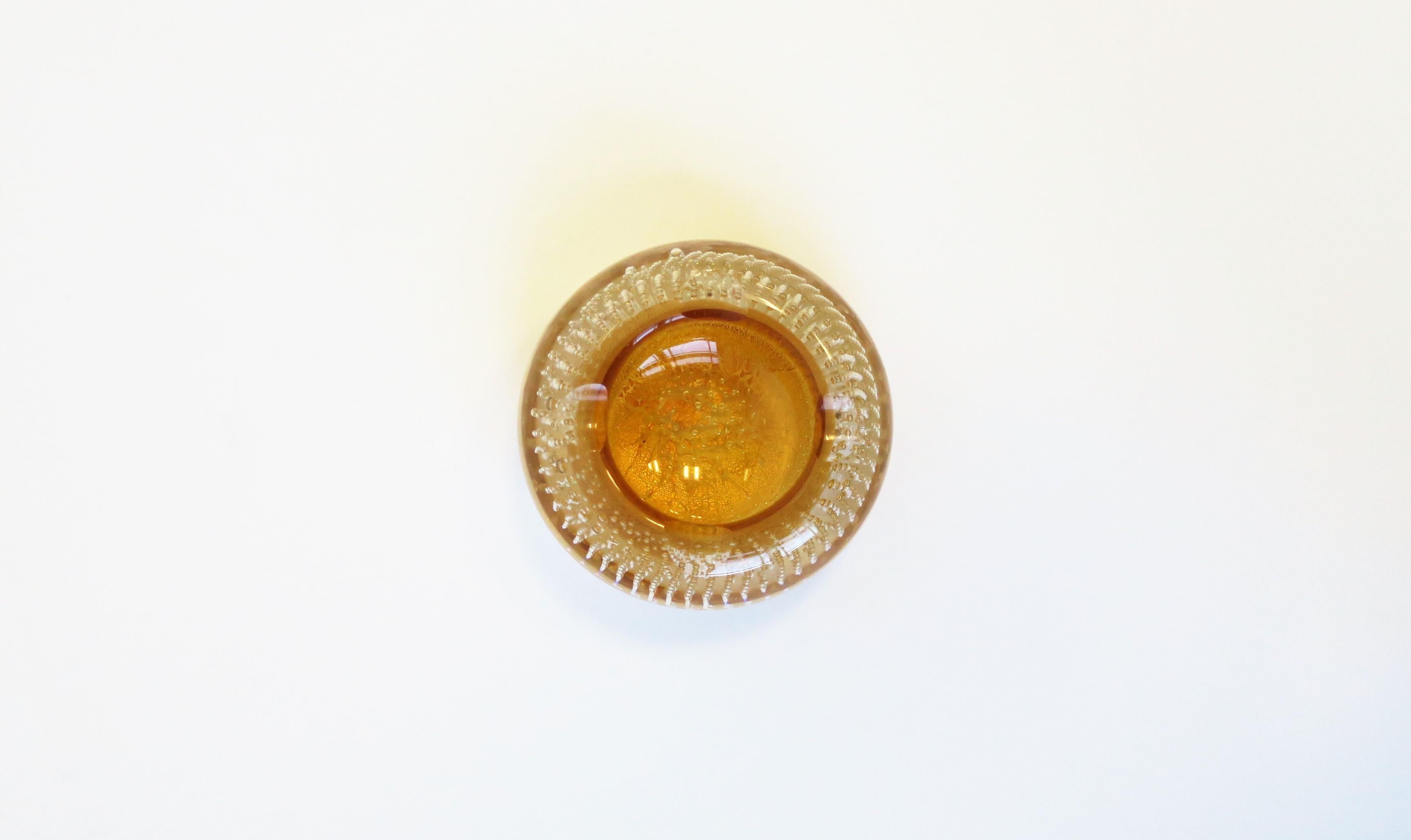 A beautiful Italian Murano 'Bullicante' golden yellow art glass ashtray or jewelry dish, circa mid to late-20th century, Italy. This Murano art glass piece is clear transparent with a golden yellow and shimmering gold leaf. Piece has a very small
