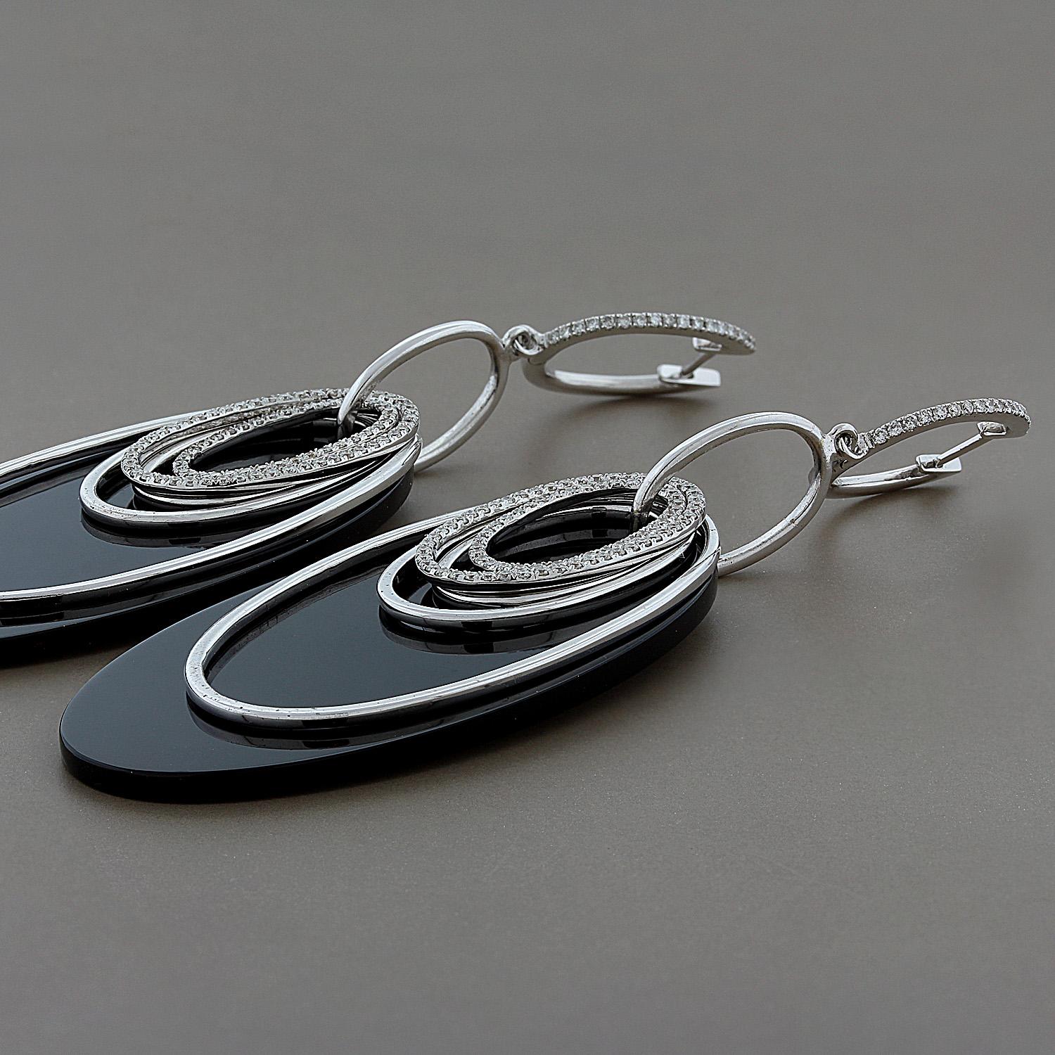 A special pair of earrings designed and crafted in Italy. They feature two smooth pieces of sleek black onyx which is the backdrop for 5 white gold hoop drops. The difference in color between the black onyx, white gold and 1.43 carats of diamond