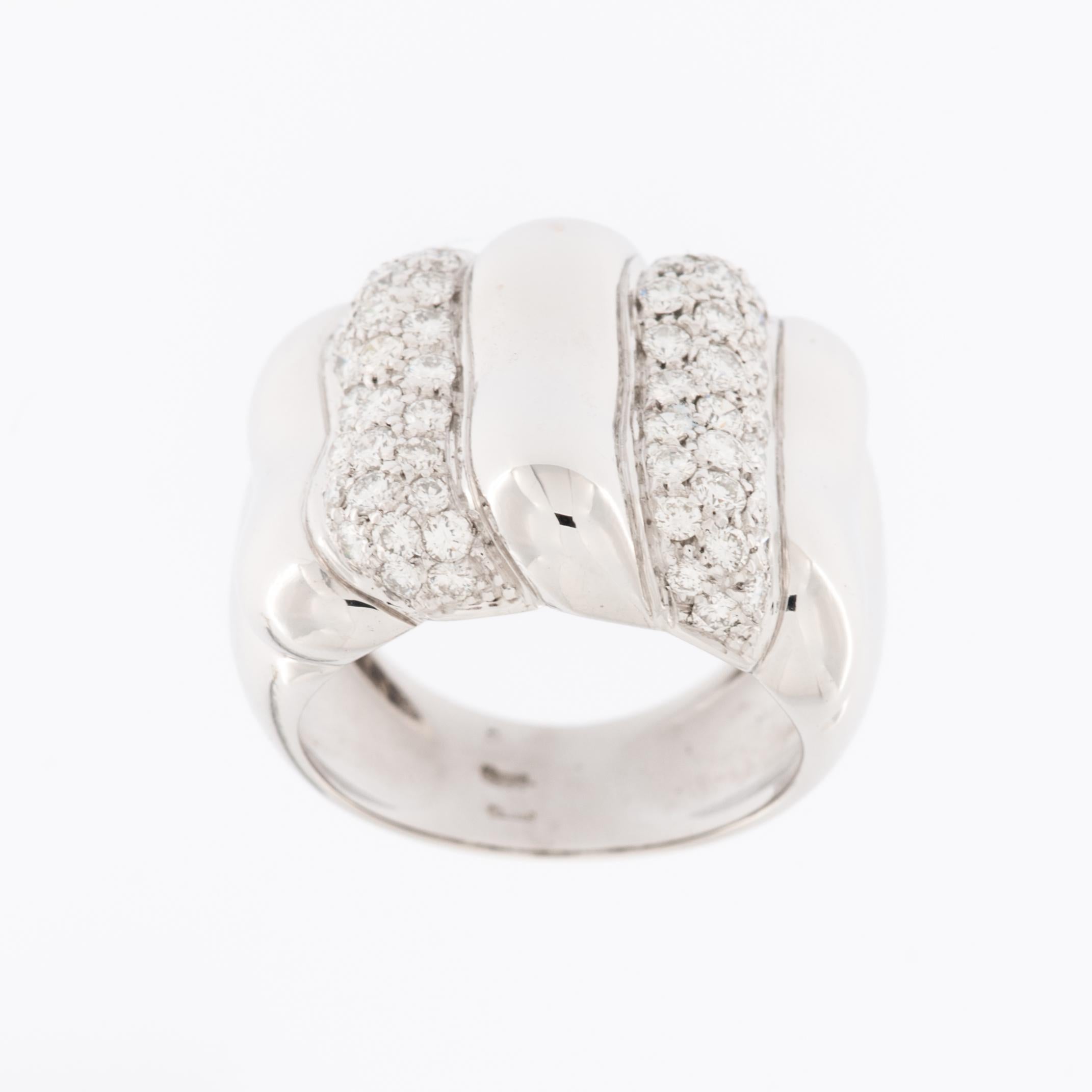 The Modern Italian Ring in 18kt White Gold with Diamonds relief work is a stunning piece of jewelry that combines contemporary design with luxurious materials. 

This ring is crafted from 18-karat white gold, a precious metal known for its lustrous,