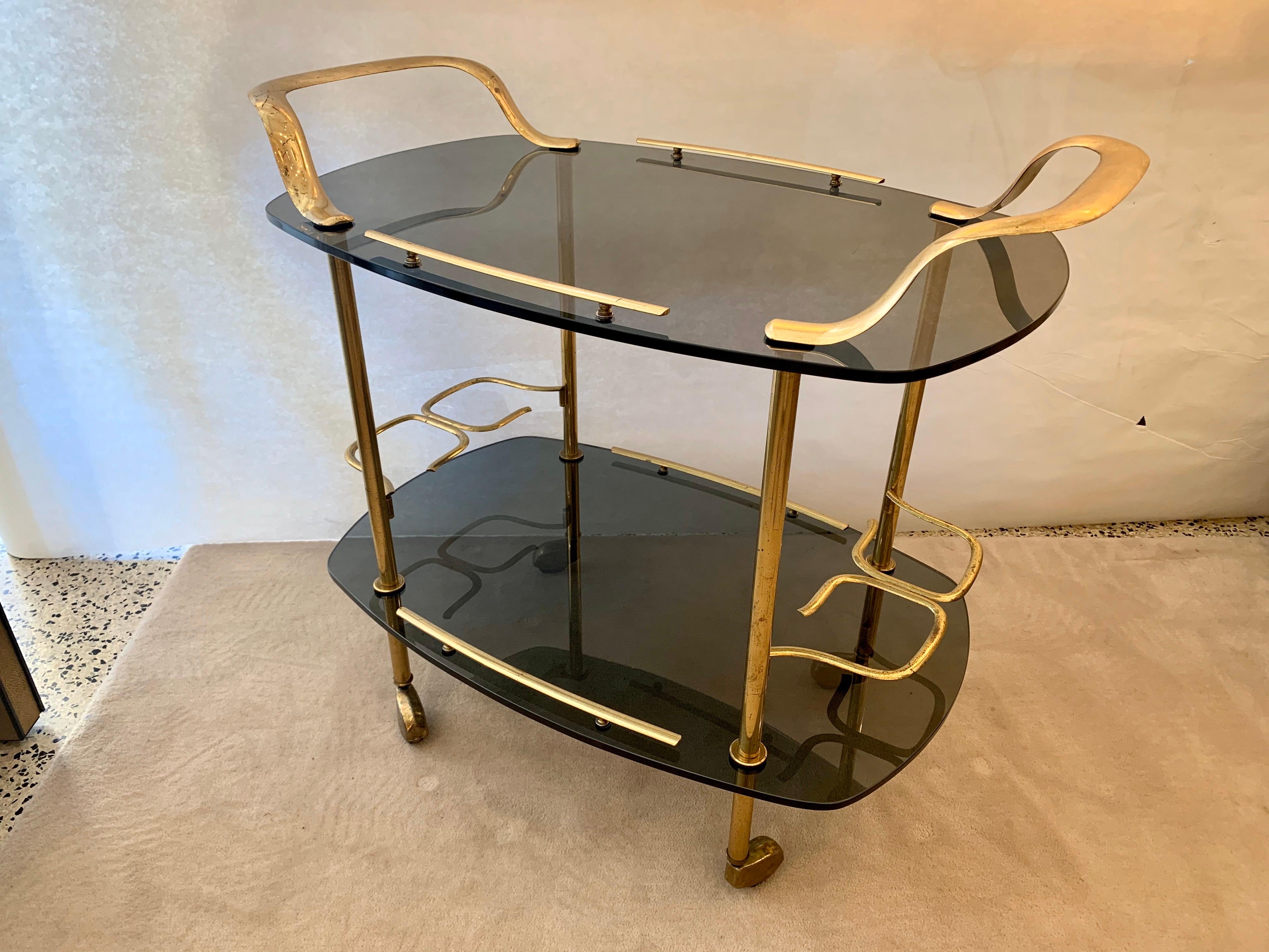 Fontana Arte attributed. bar cart with smoked gray glass (two tiers) and all brass fixtures including casters. Wonderful details and rolls easily.